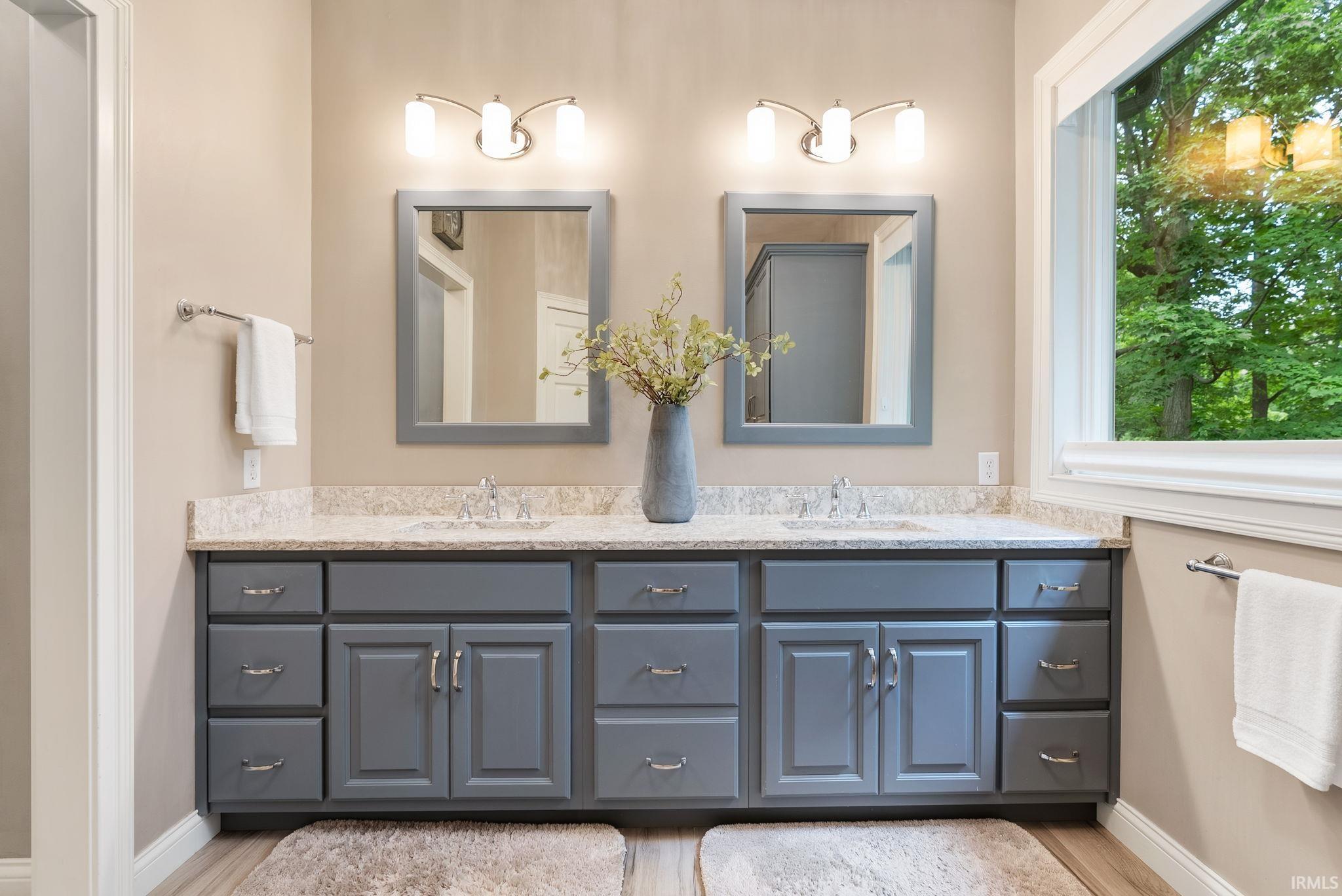 Dual vanity with gray cabinetry, light-toned countertop, and integrated sinks