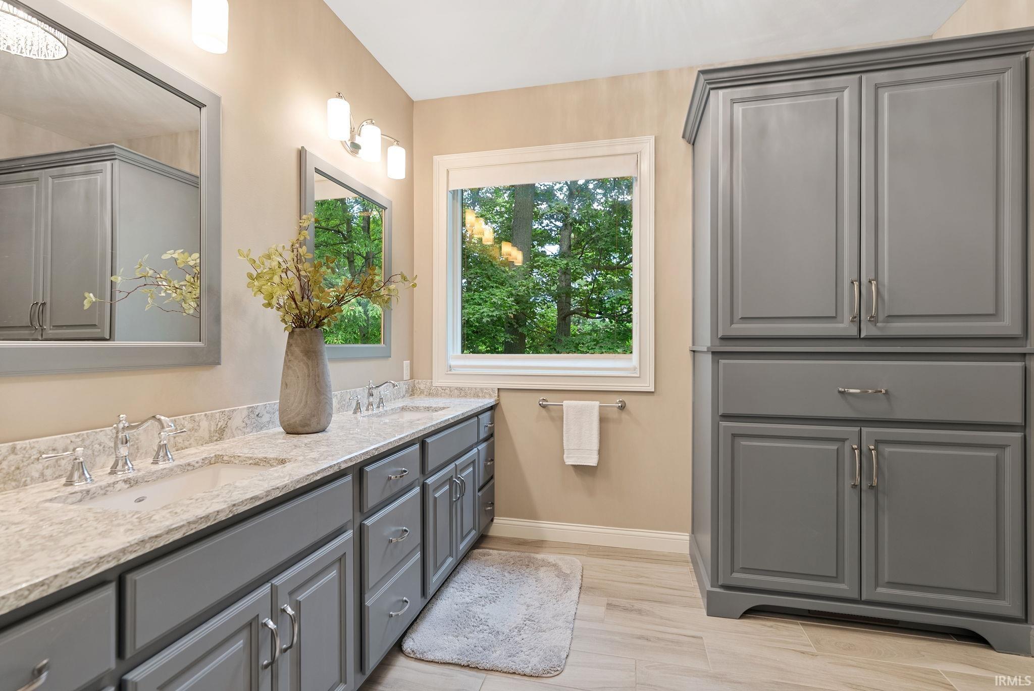 Dual vanity with integrated sinks, light-toned countertop, and gray shaker-style cabinetry