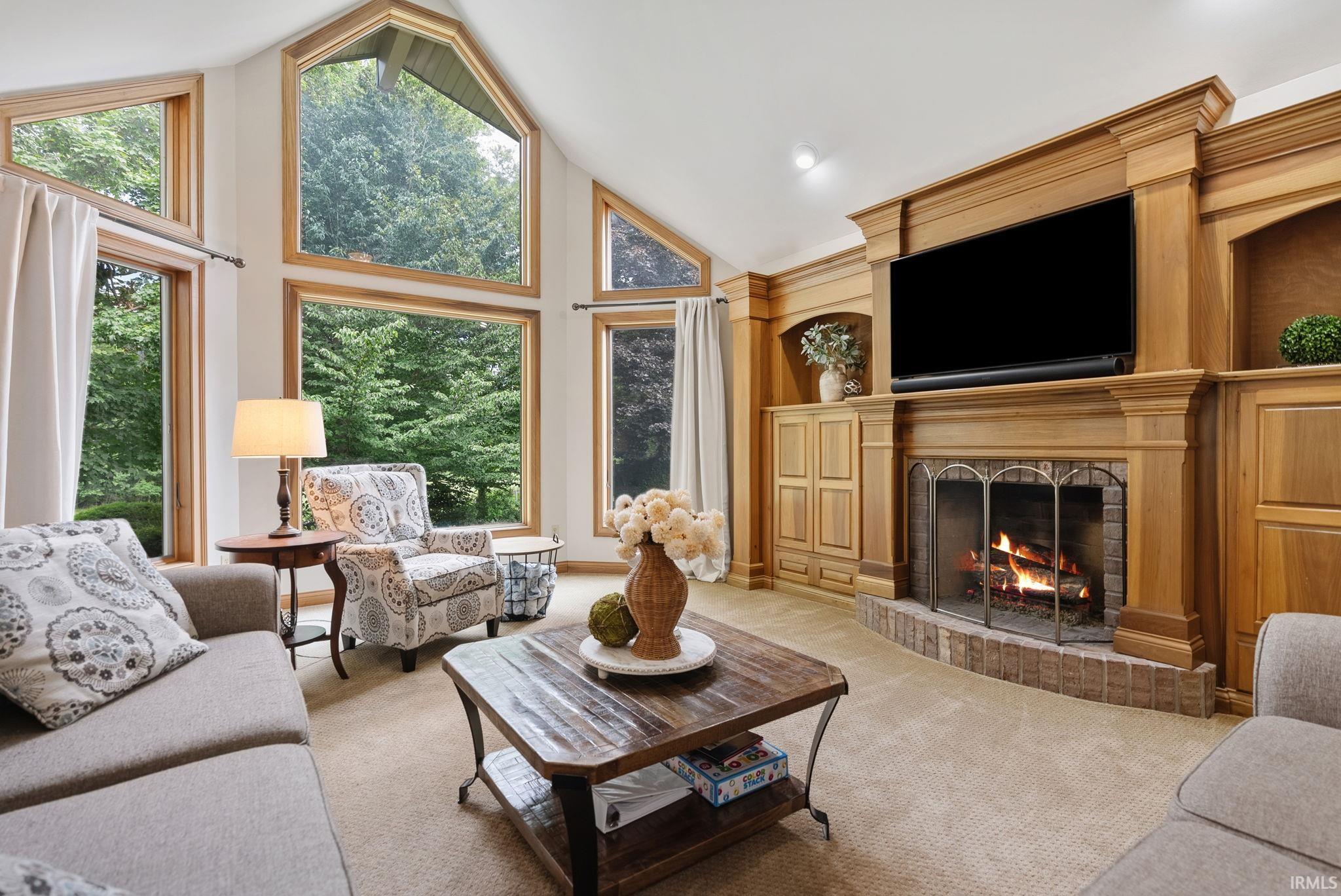 Expansive living area featuring a vaulted ceiling and an array of large windows
