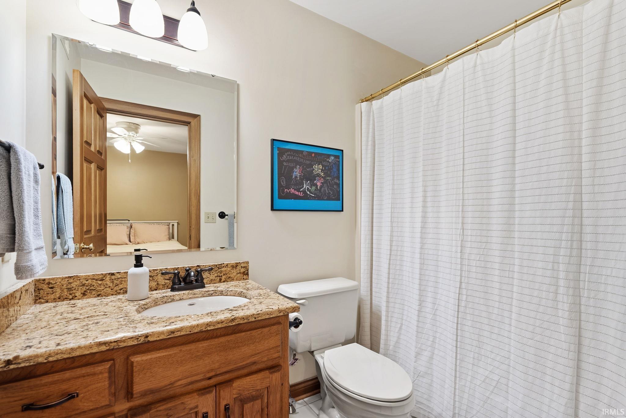 Bathroom vanity featuring a granite countertop with an undermount sink and wood cabinetry