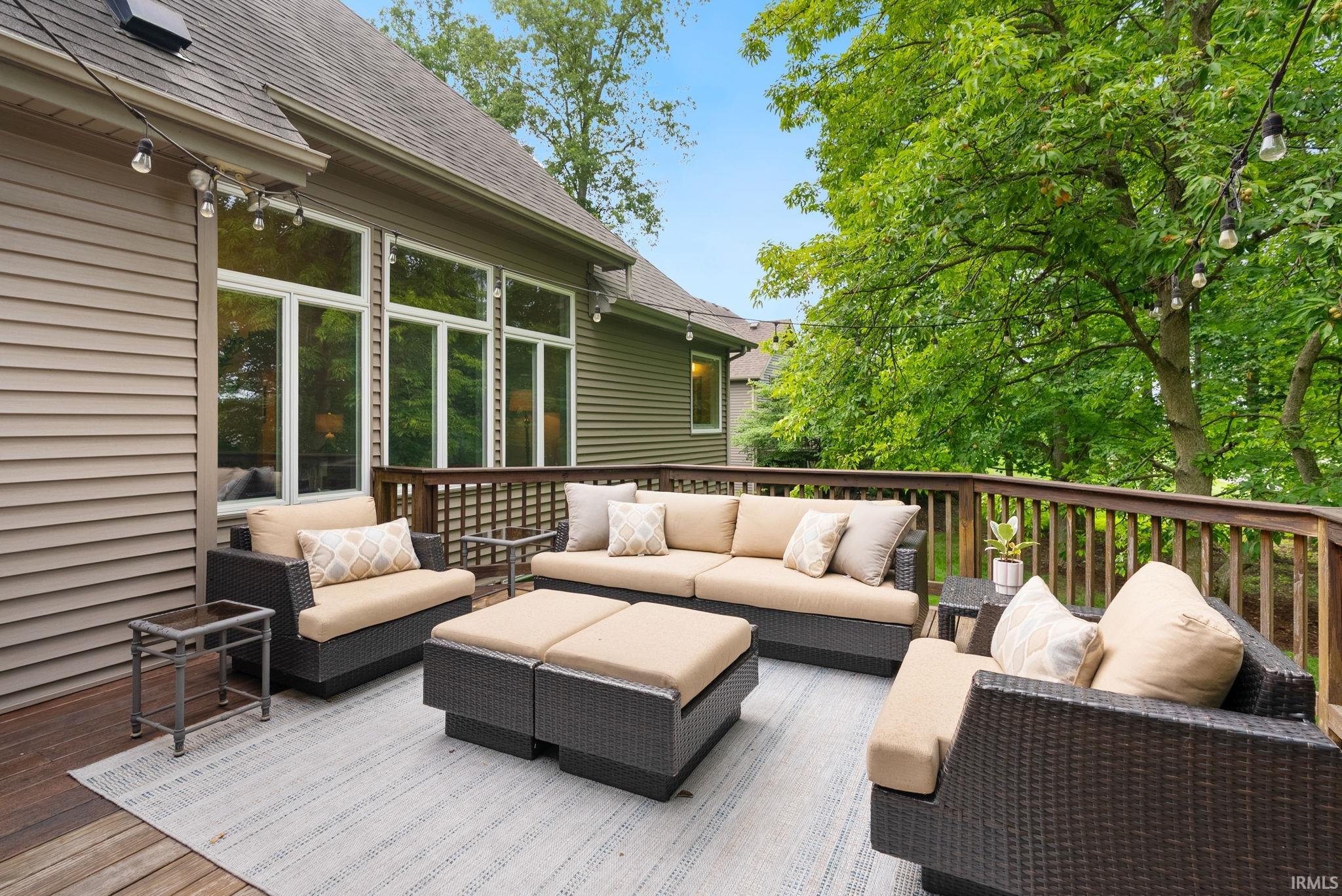 Spacious wooden deck featuring a full railing system, ample room for outdoor furnishings, large pane windows, and horizontal siding