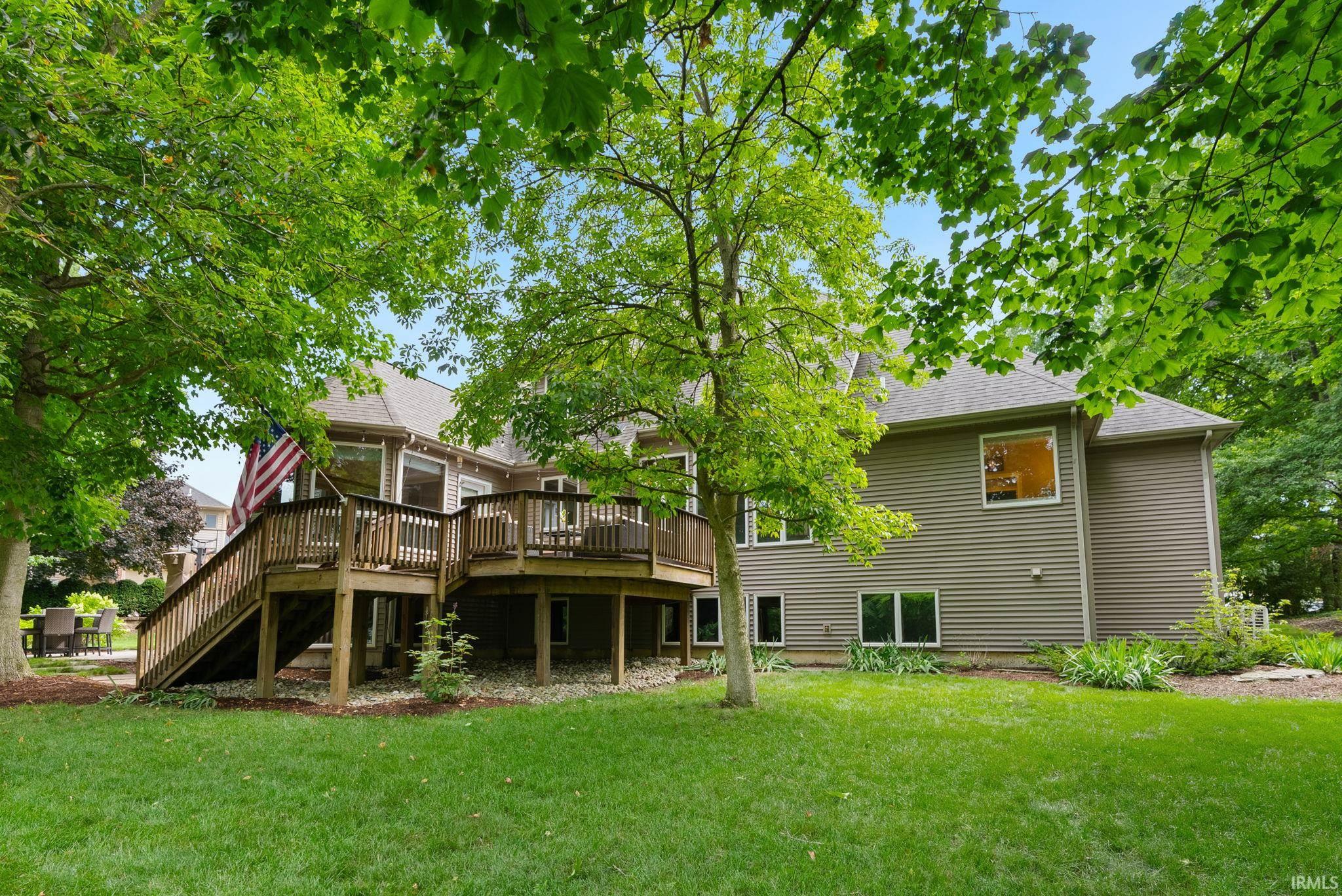 Expansive green lawn with mature trees providing a natural canopy