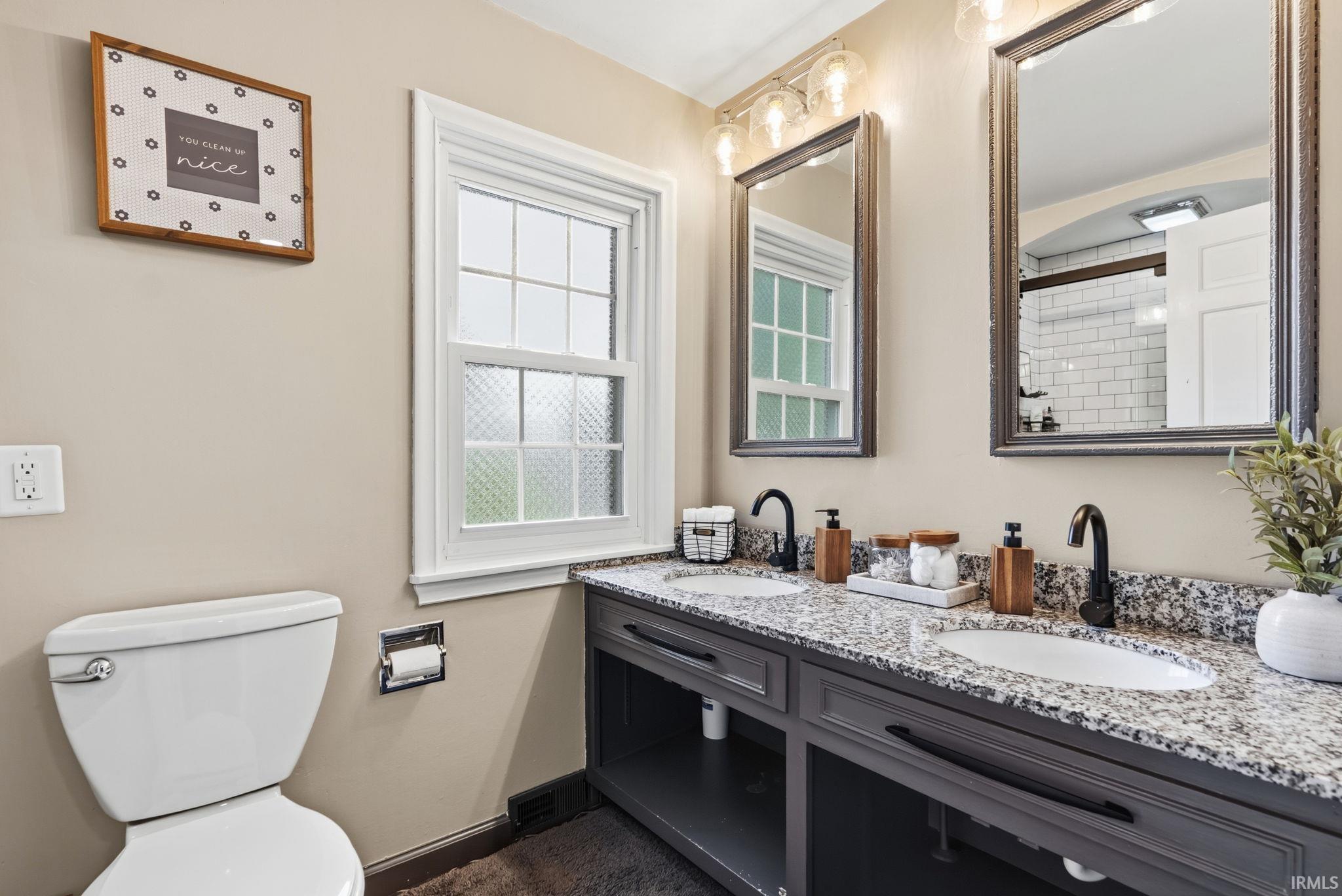 Dual vanity with granite countertop, undermount sinks, and matte black fixtures