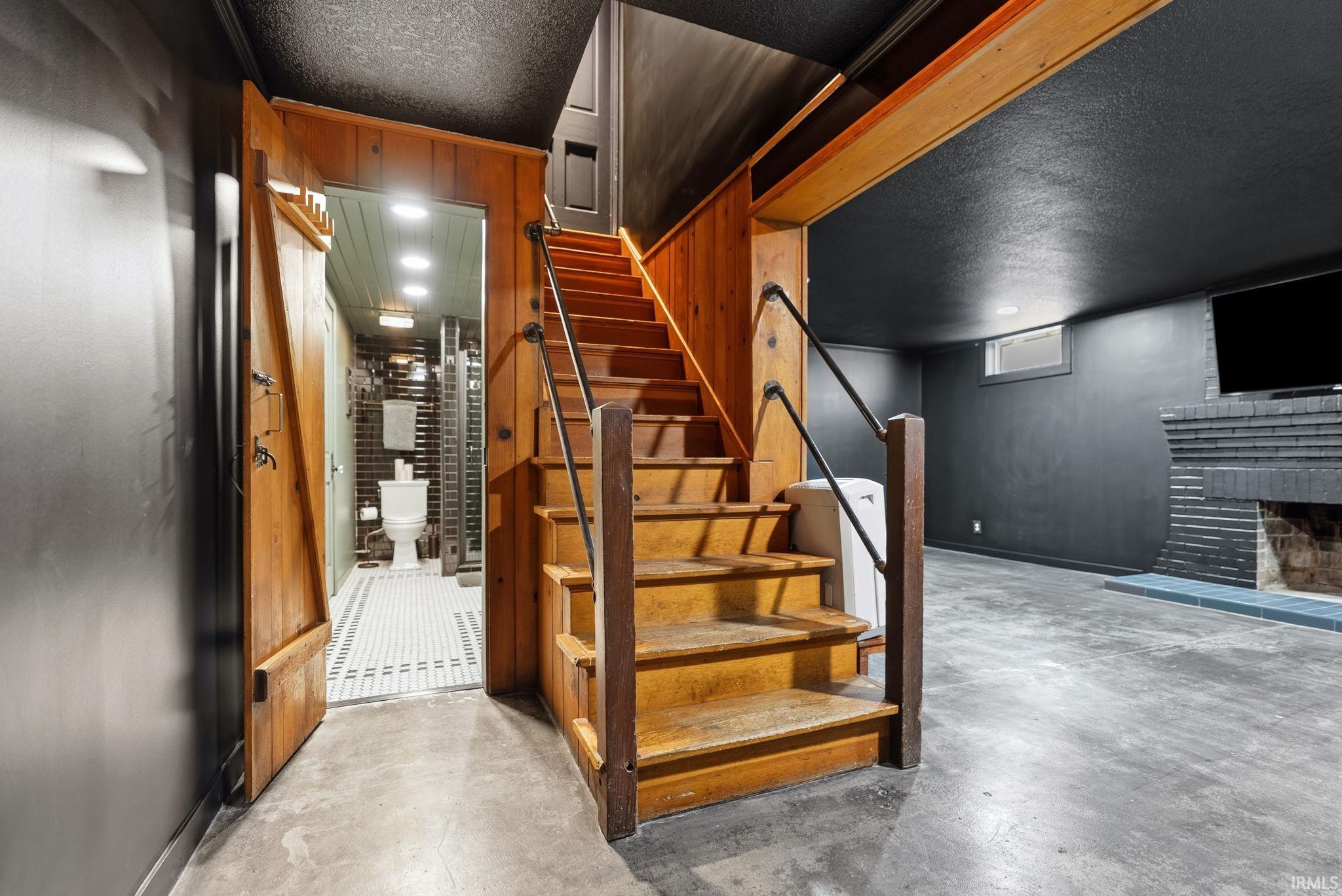 Wood-paneled staircase with industrial-style handrails