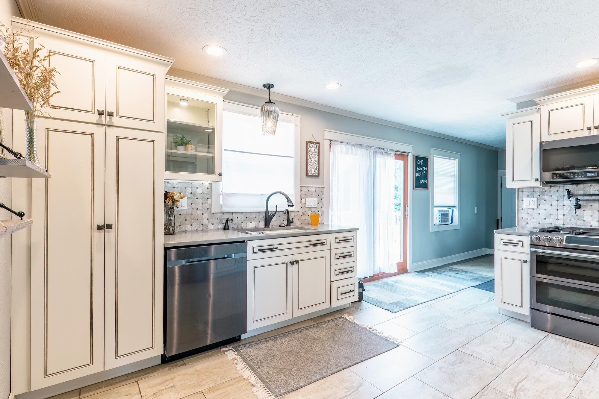 Kitchen featuring white cabinetry, stainless steel appliances, a tiled backsplash, recessed lighting, and tile flooring
