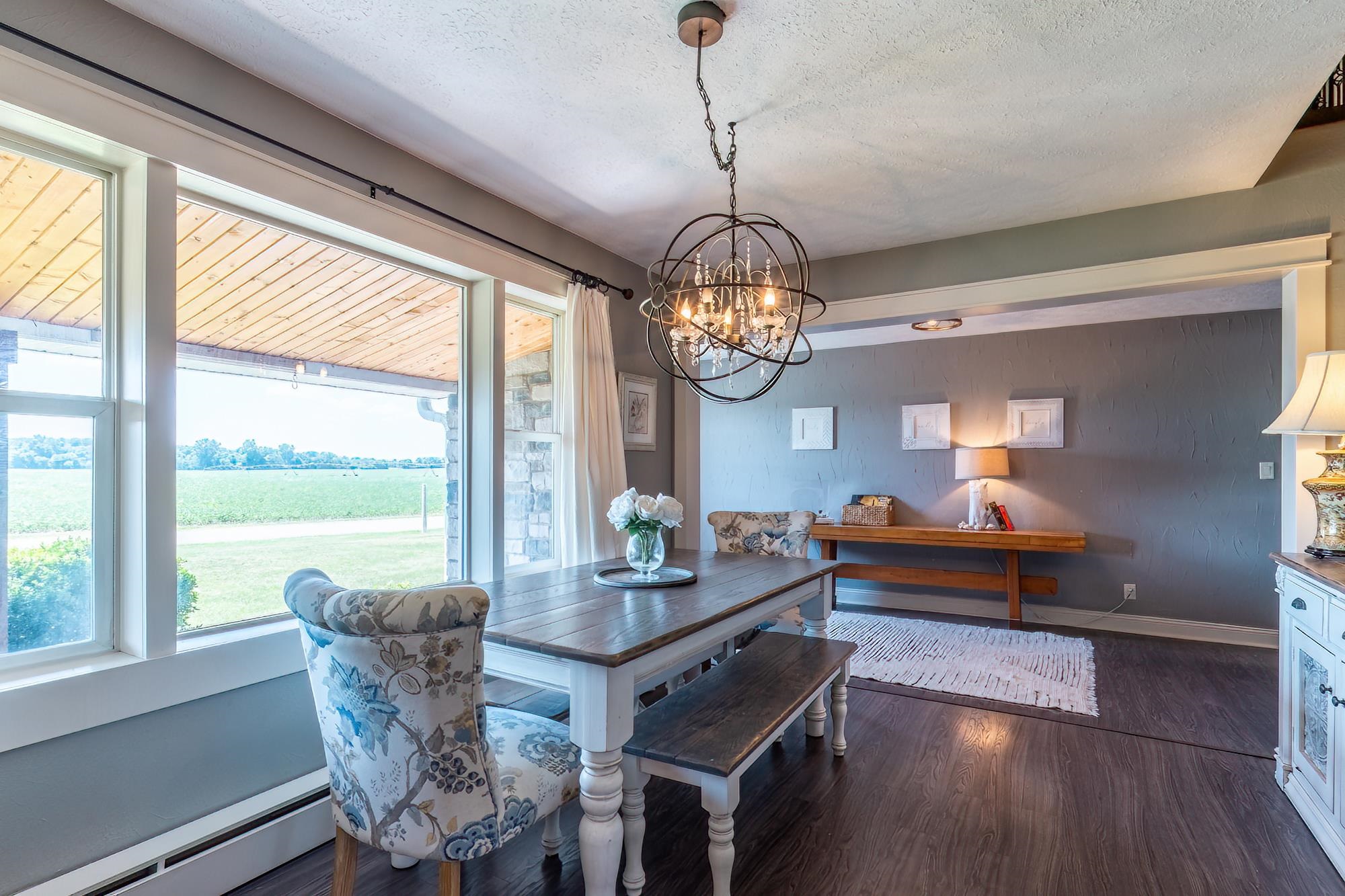 Dining area featuring large windows, wood-finish flooring, and a decorative chandelier