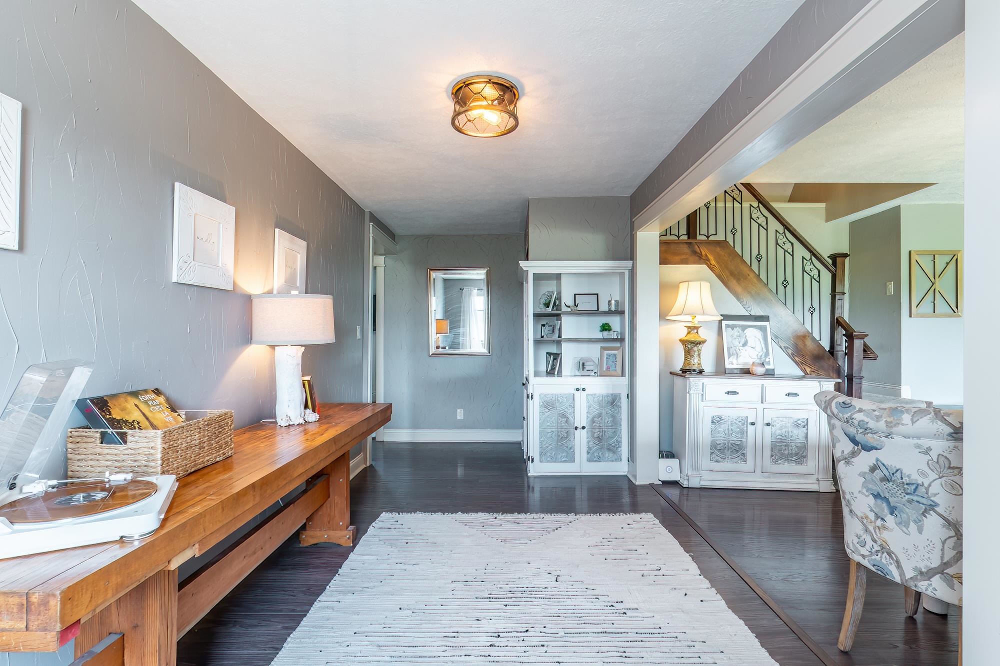 Entryway featuring dark wood-finish flooring, textured gray wall paint, and a decorative ceiling light fixture