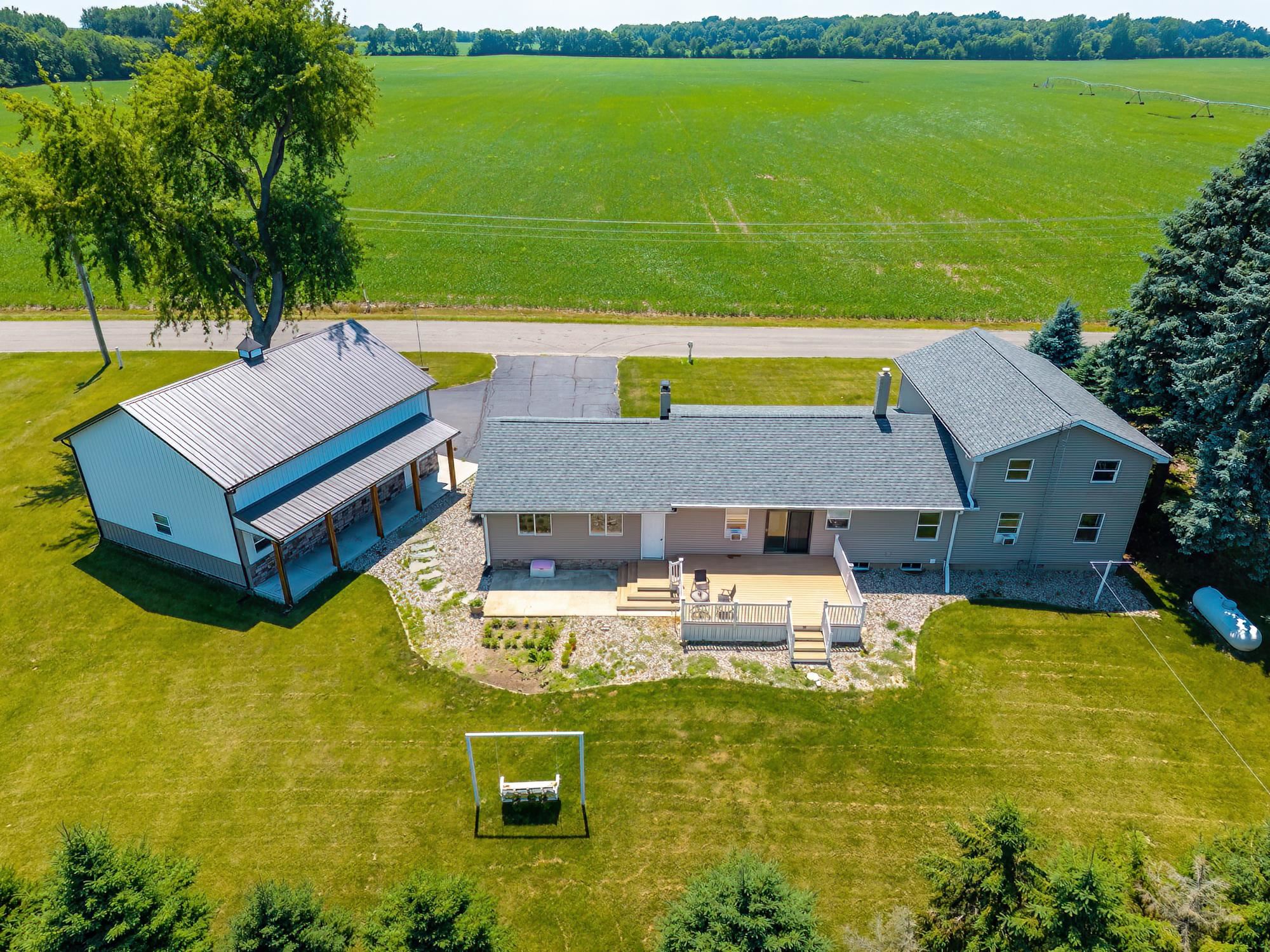 Expansive property featuring a two-story residence with a multi-level deck and an additional detached barn structure