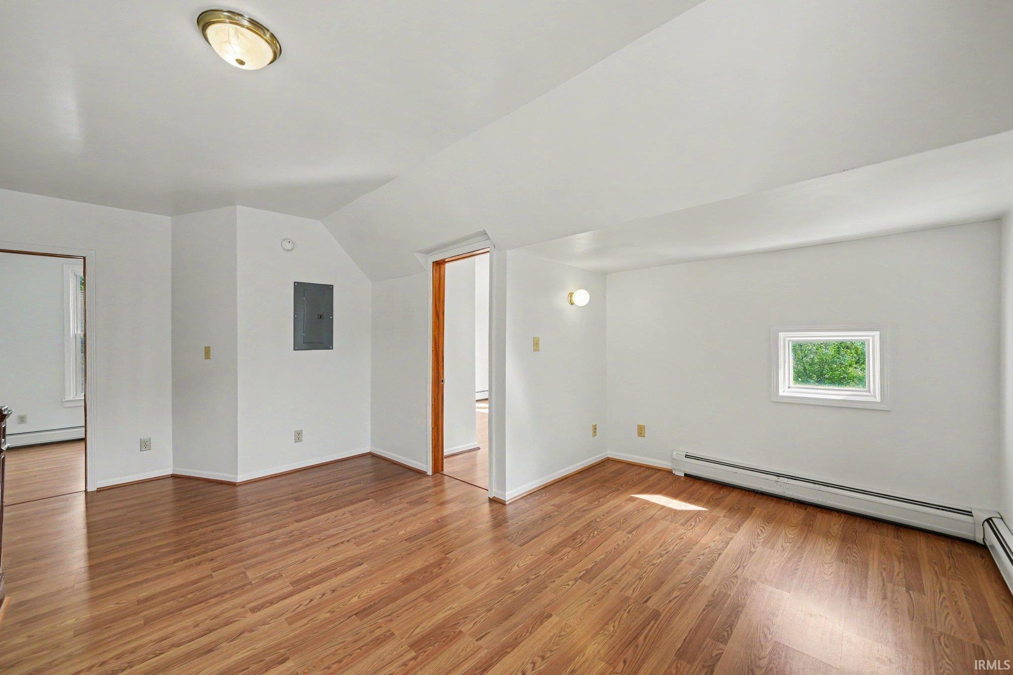 Room featuring wood-finish flooring, white walls, and a recessed window