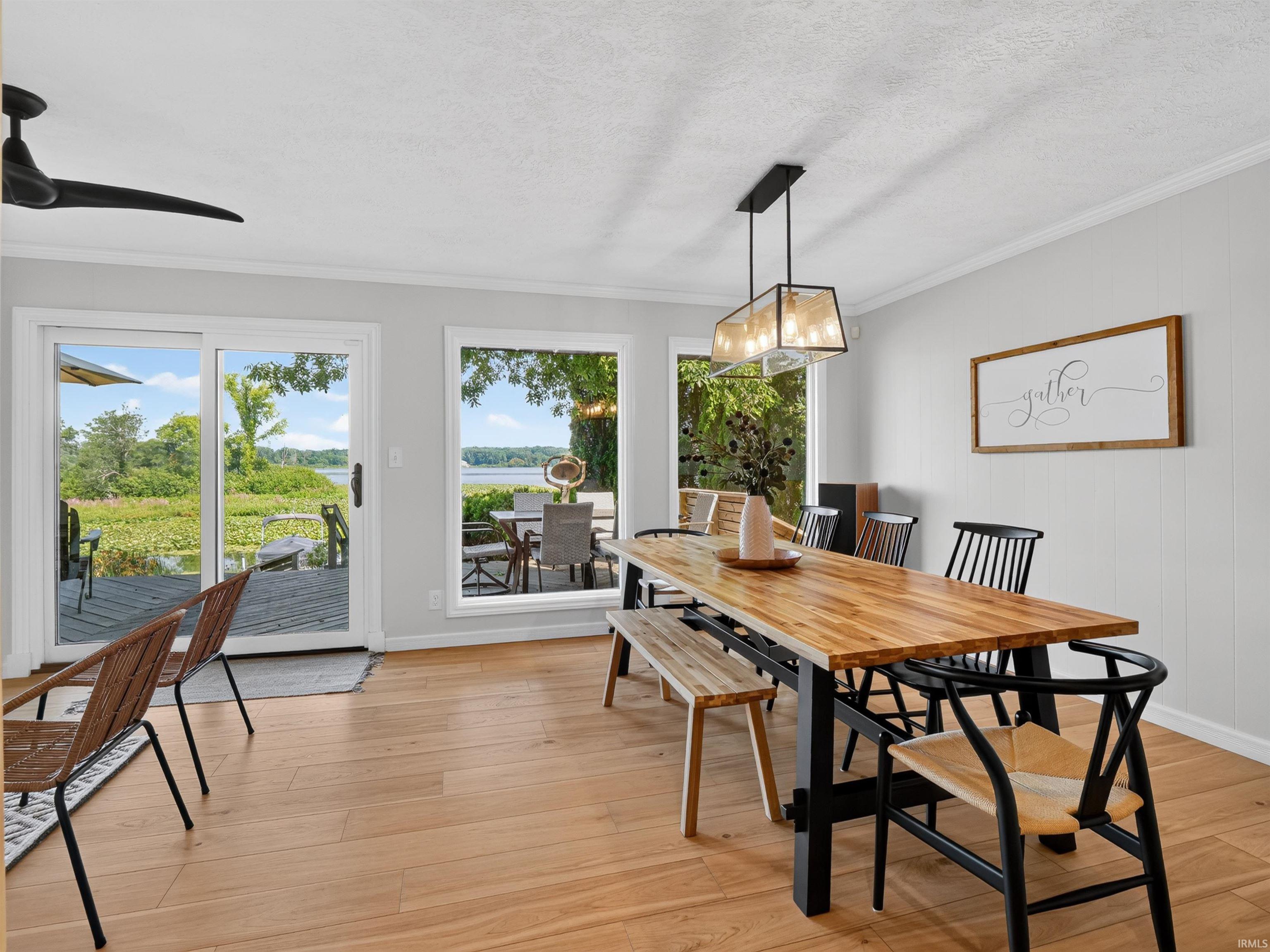 Dining area featuring wood-finish flooring, white trim, and a linear chandelier