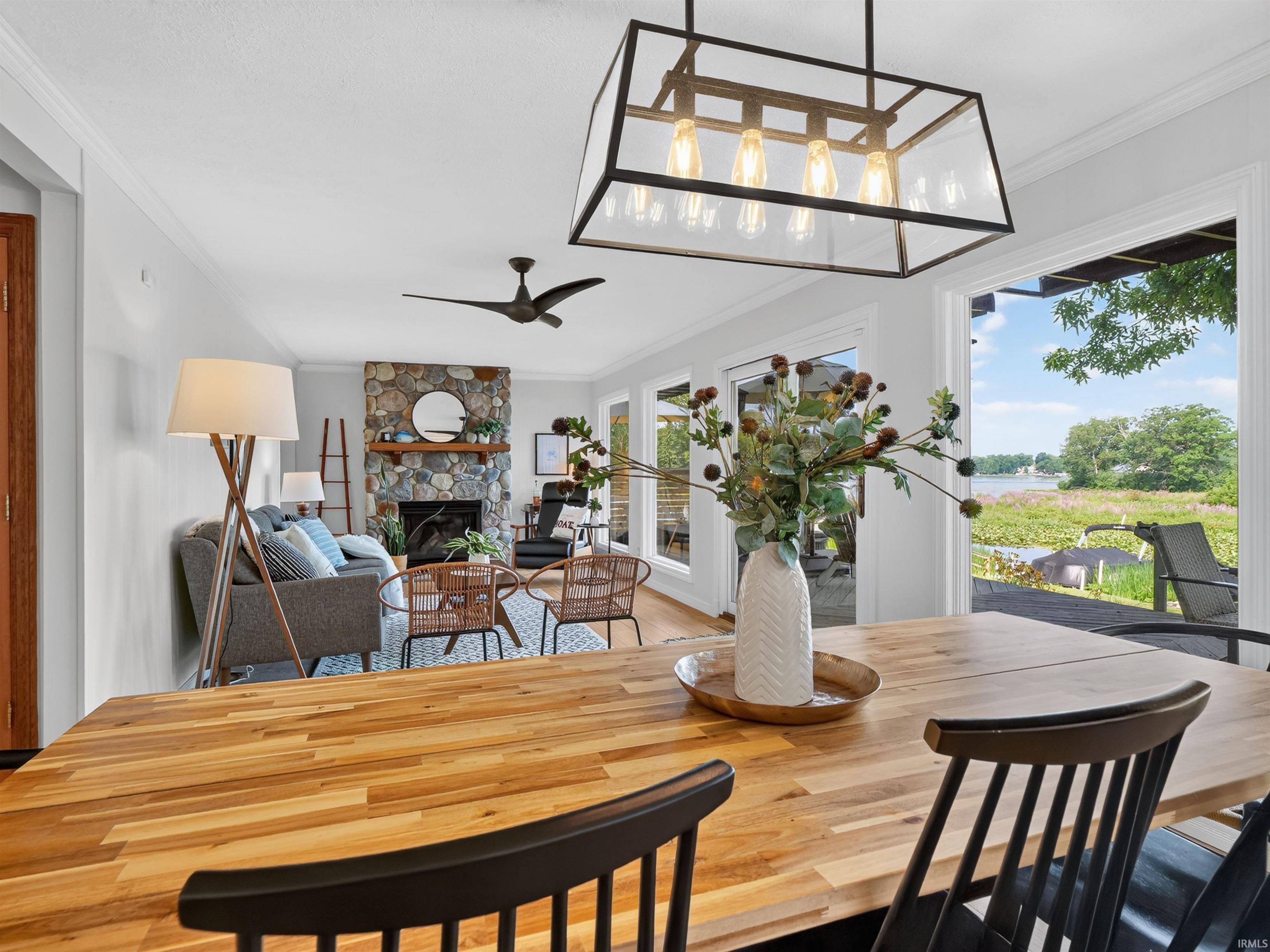 Open-concept living space featuring a wood-finish dining table and a multi-light linear chandelier