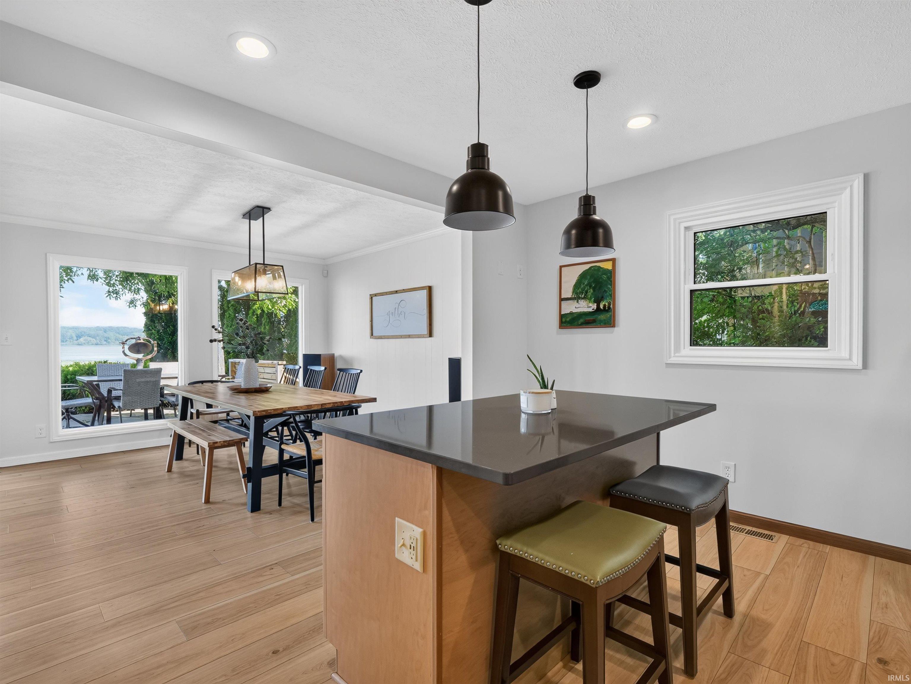 Kitchen island featuring a dark countertop and light wood-finish cabinetry