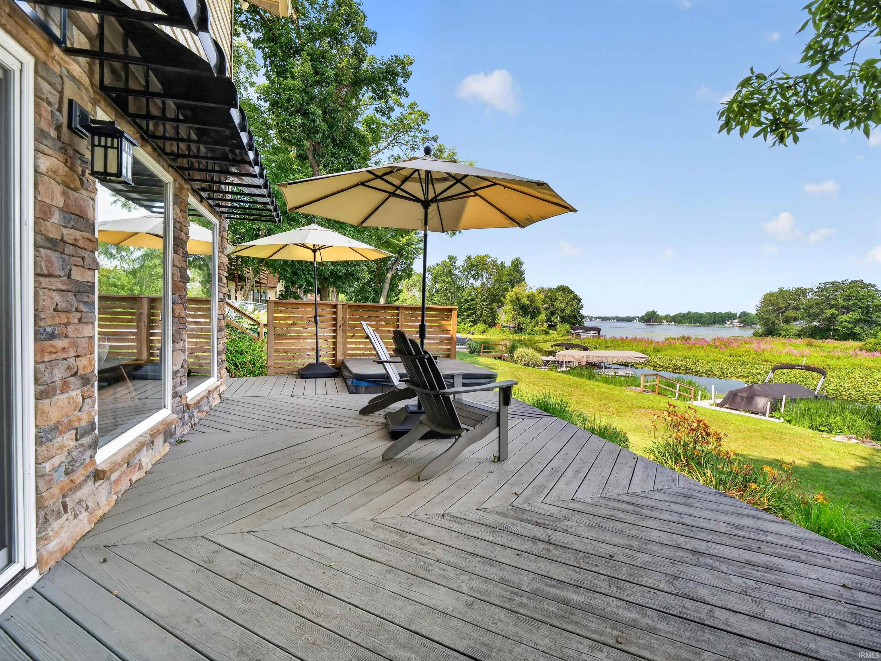 Expansive outdoor deck with wood-finish planks and a natural stone exterior wall