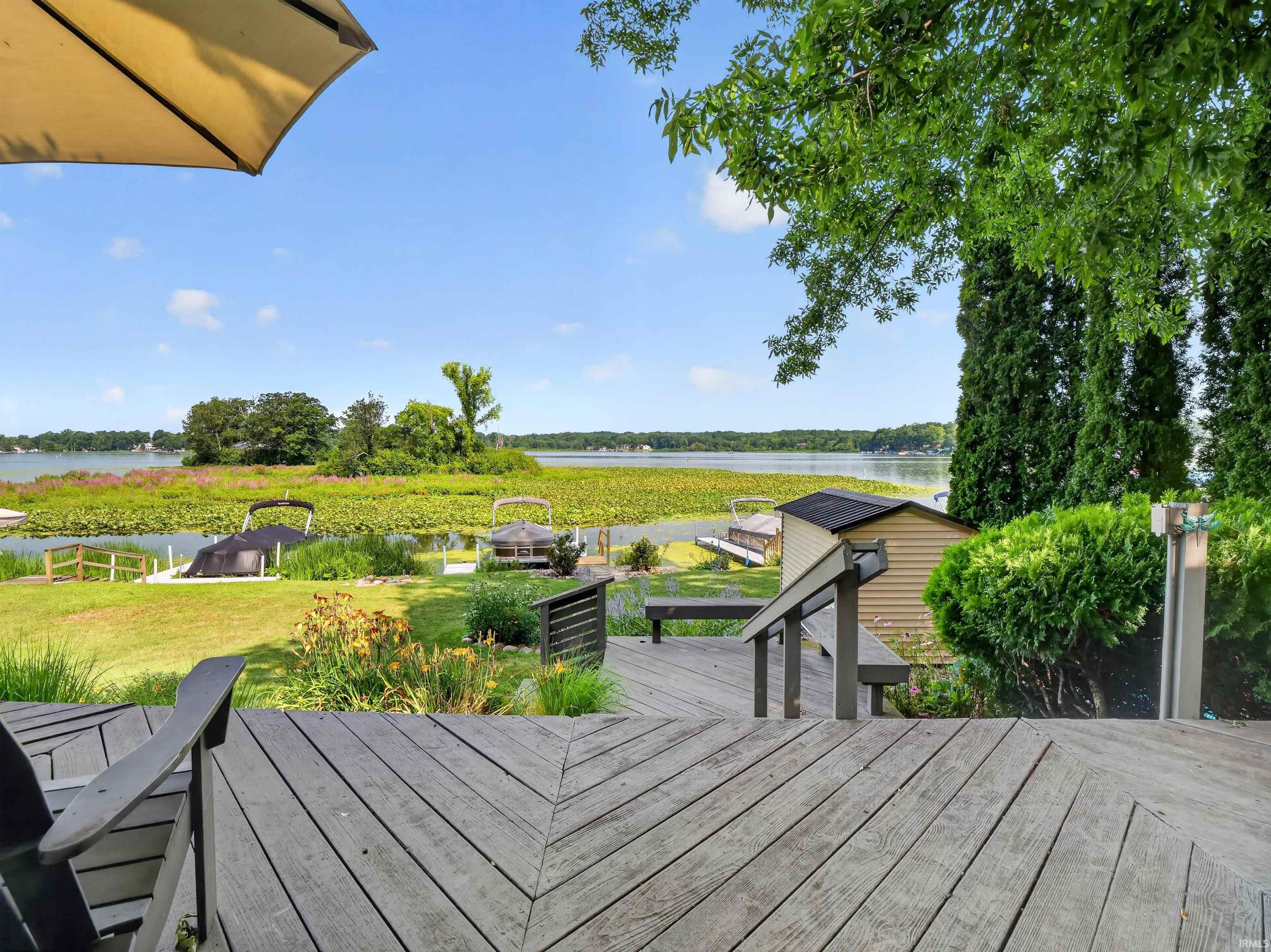 Expansive outdoor deck with a weathered wood-finish surface, featuring integrated seating and a privacy railing