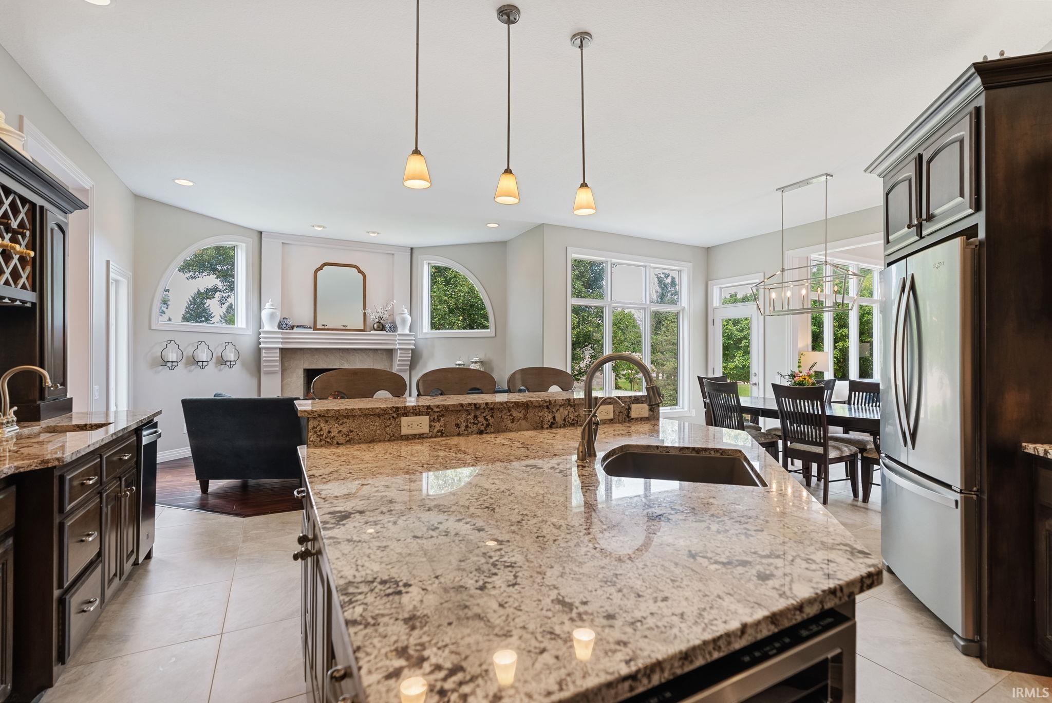 Kitchen island with stone countertop, undermount sink, and gooseneck faucet