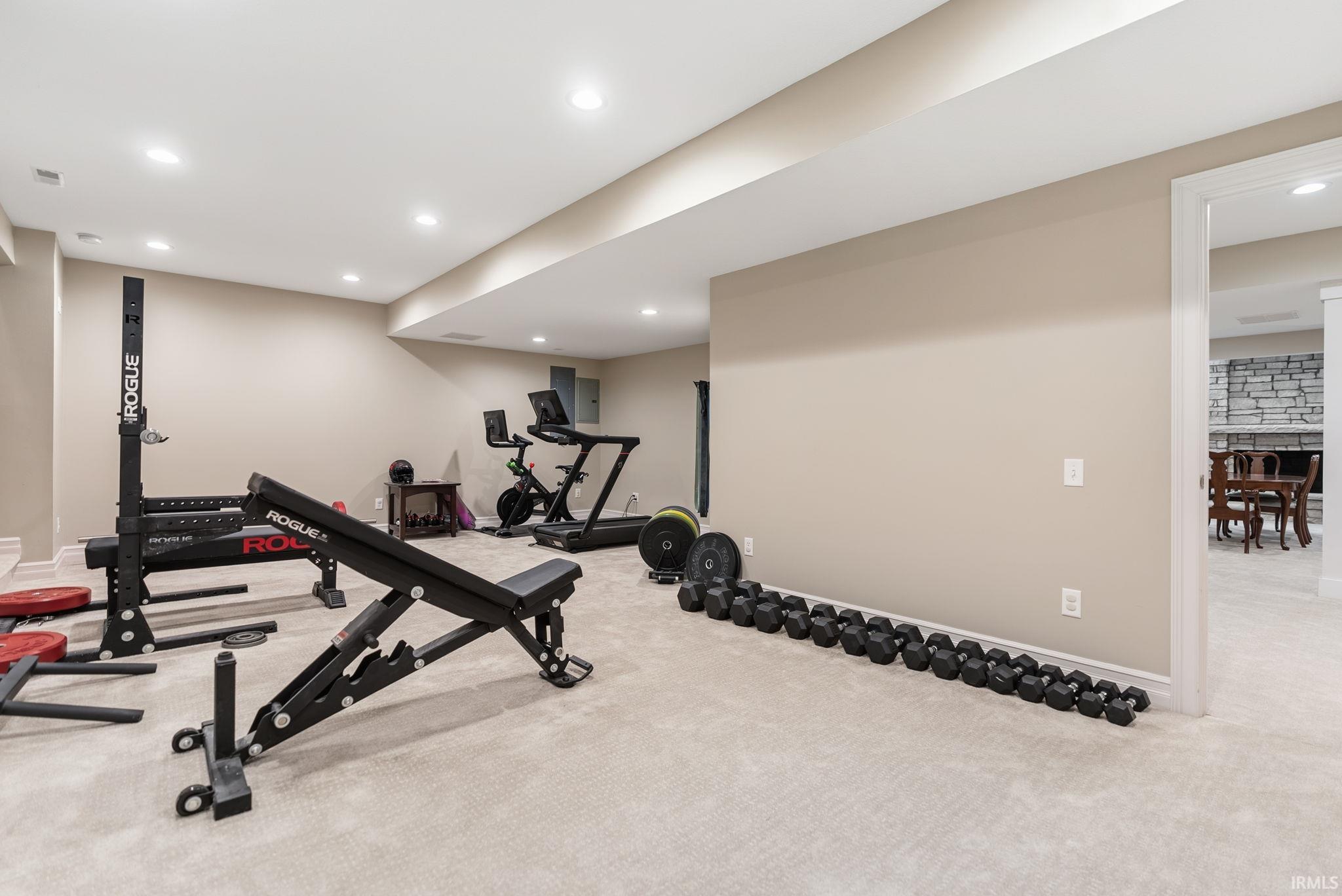 Spacious finished lower level with recessed lighting, carpeted flooring, and neutral wall tones