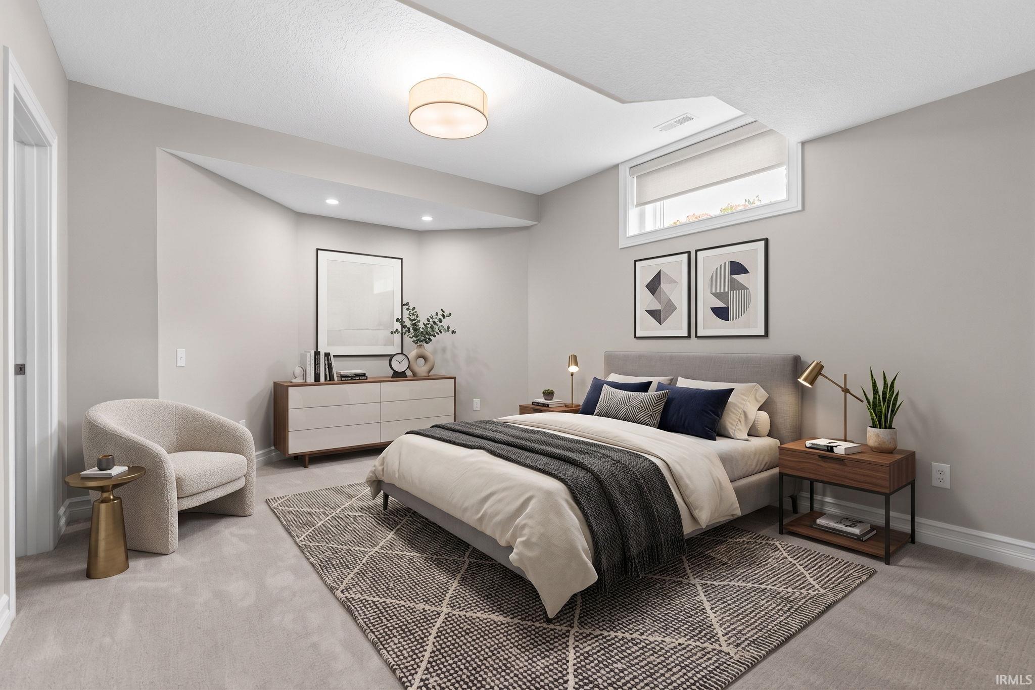 Light gray carpeting throughout this bedroom with recessed lighting and a window