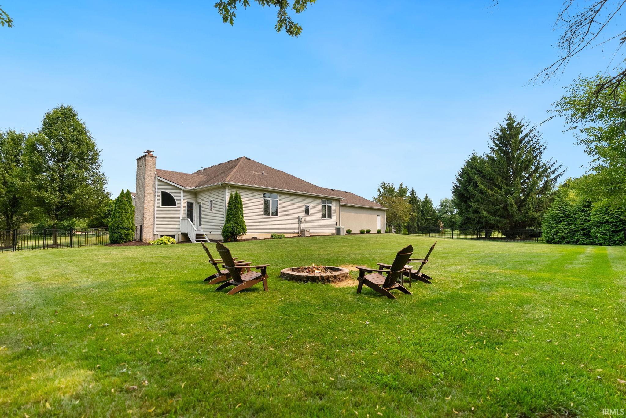 Expansive green lawn with a built-in stone fire pit