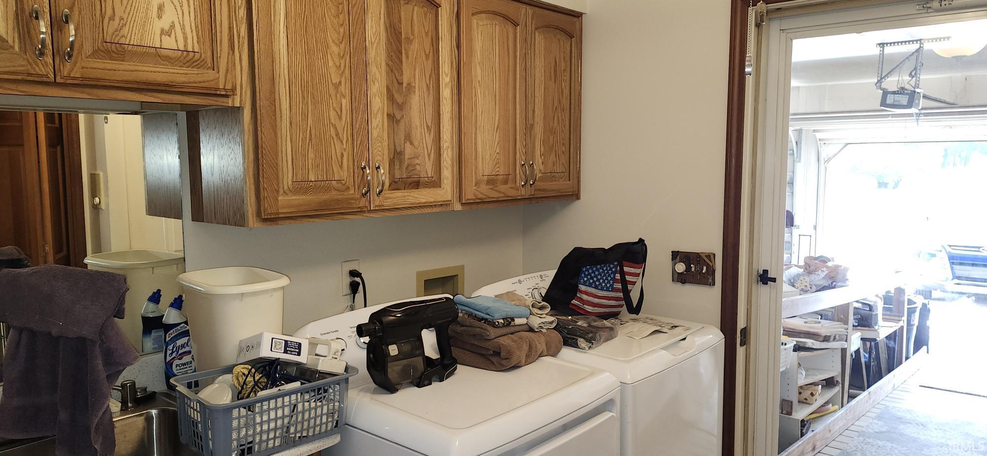 Utility space featuring ample cabinetry, a built-in sink, and direct access to an outdoor area