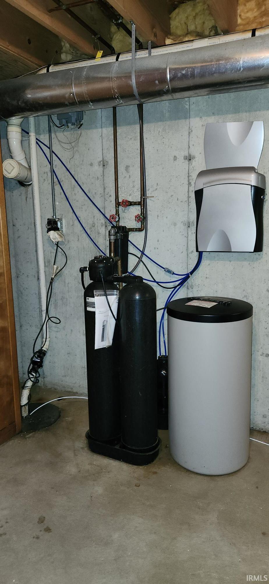 Utility area featuring a water softener system, water filtration units, and exposed ductwork