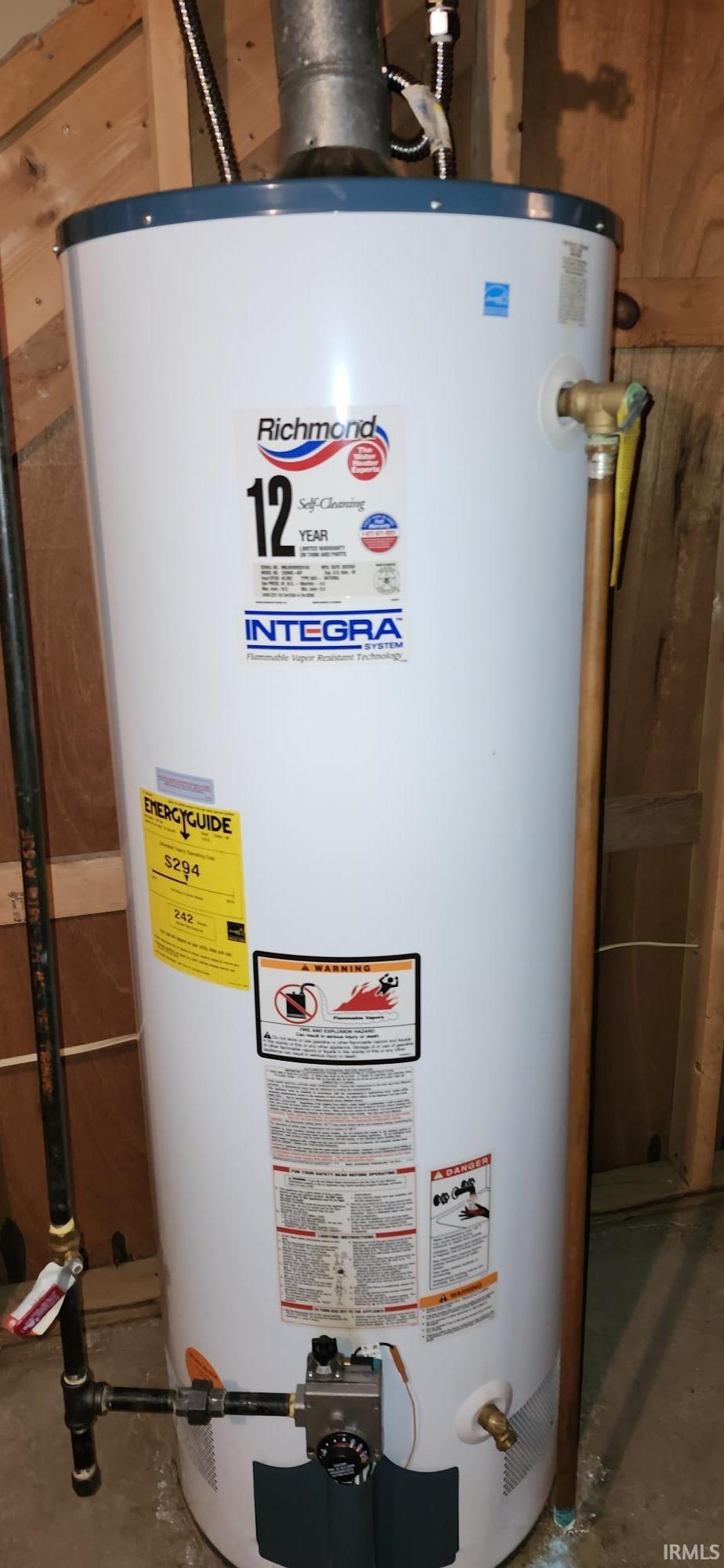 White water heater unit with visible gas lines and a brass valve