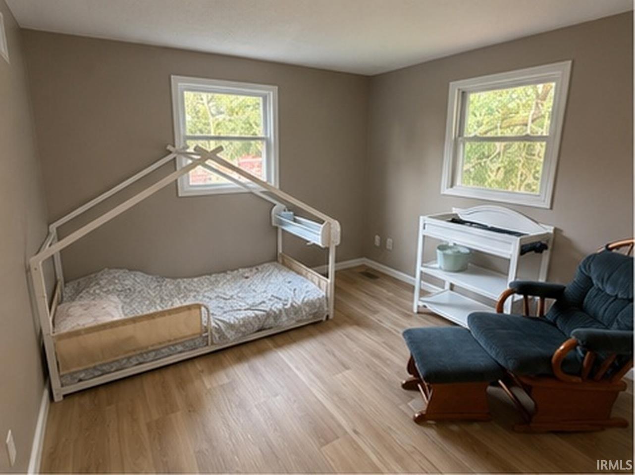 Room featuring light wood-finish flooring, neutral wall tones, and white trim