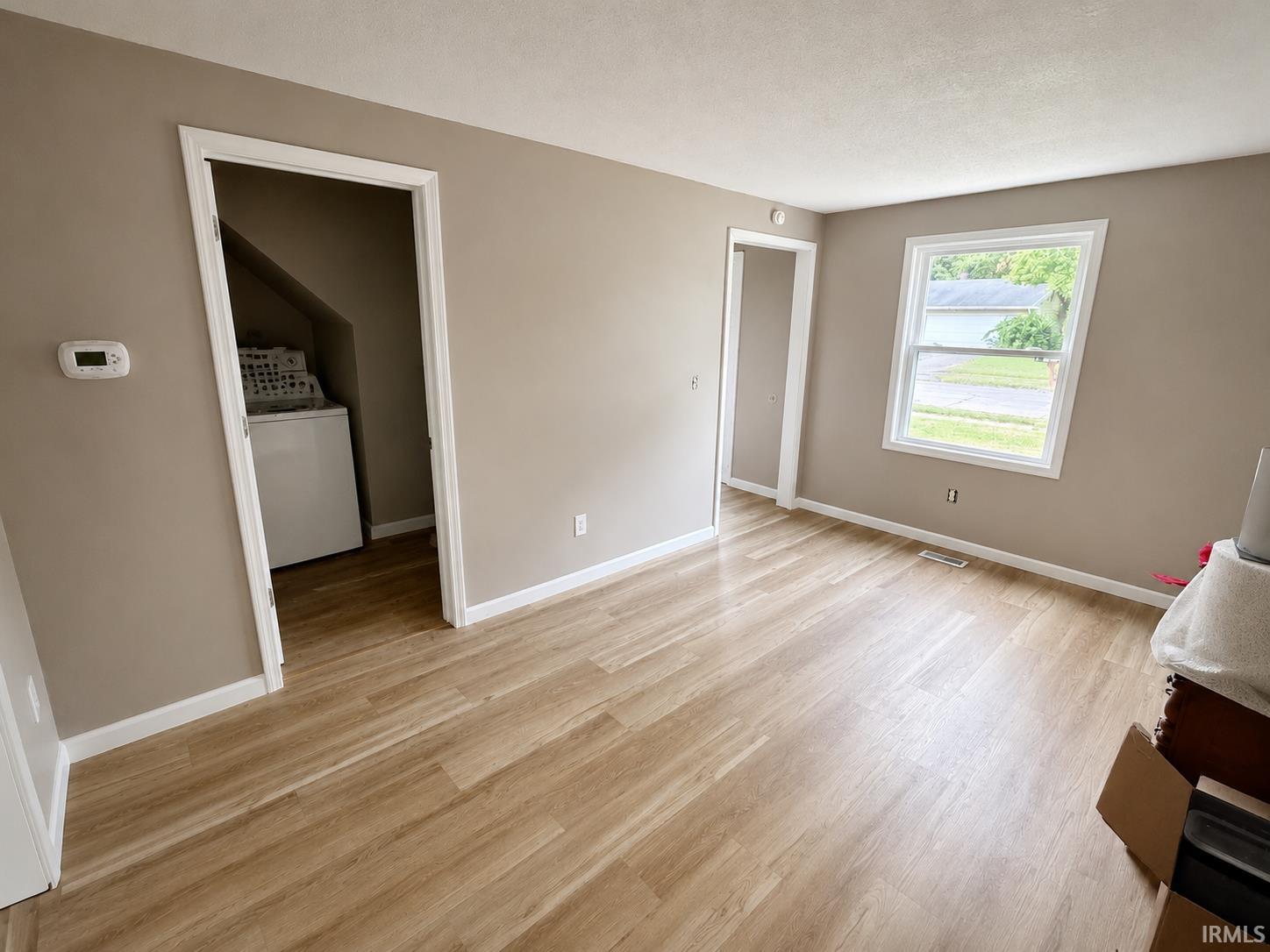 Neutral-toned walls complement the wood-finish flooring throughout this open space
