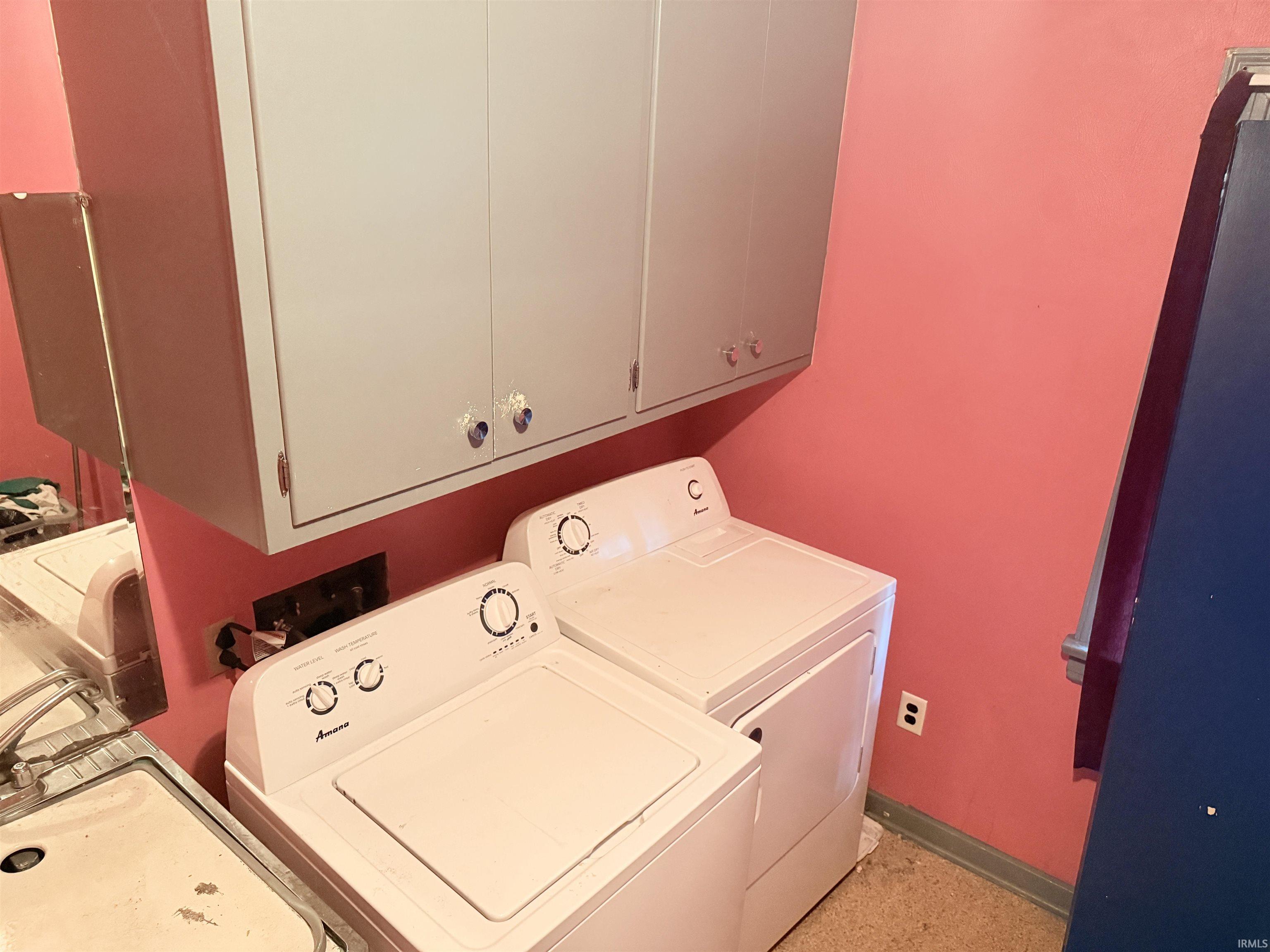 Laundry area featuring overhead cabinetry, a utility sink, and appliance hookups