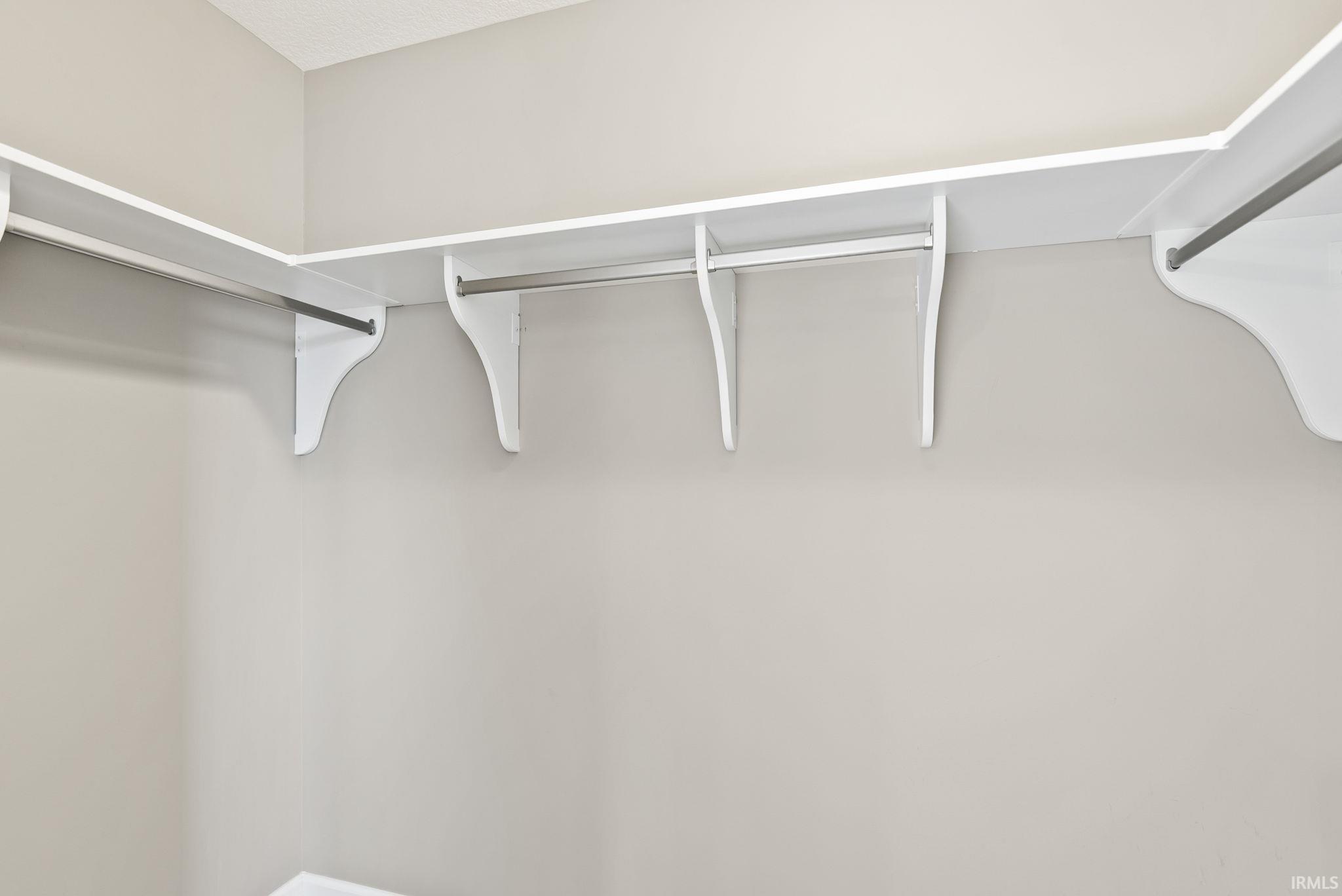 Built-in closet shelving and hanging rods offer organized storage solutions