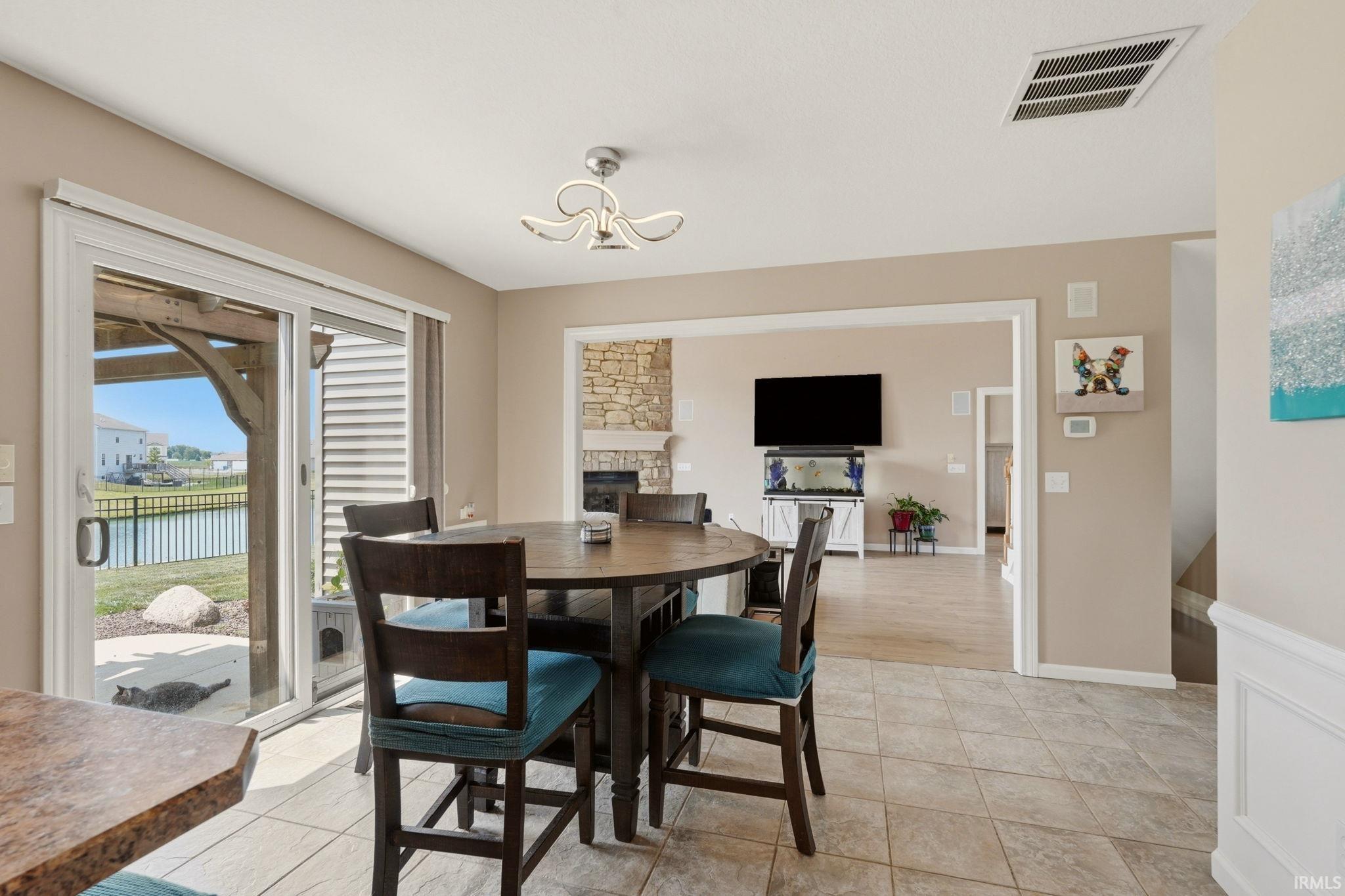 Dining area featuring tile flooring, a contemporary chandelier, and sliding glass doors to the outdoor patio