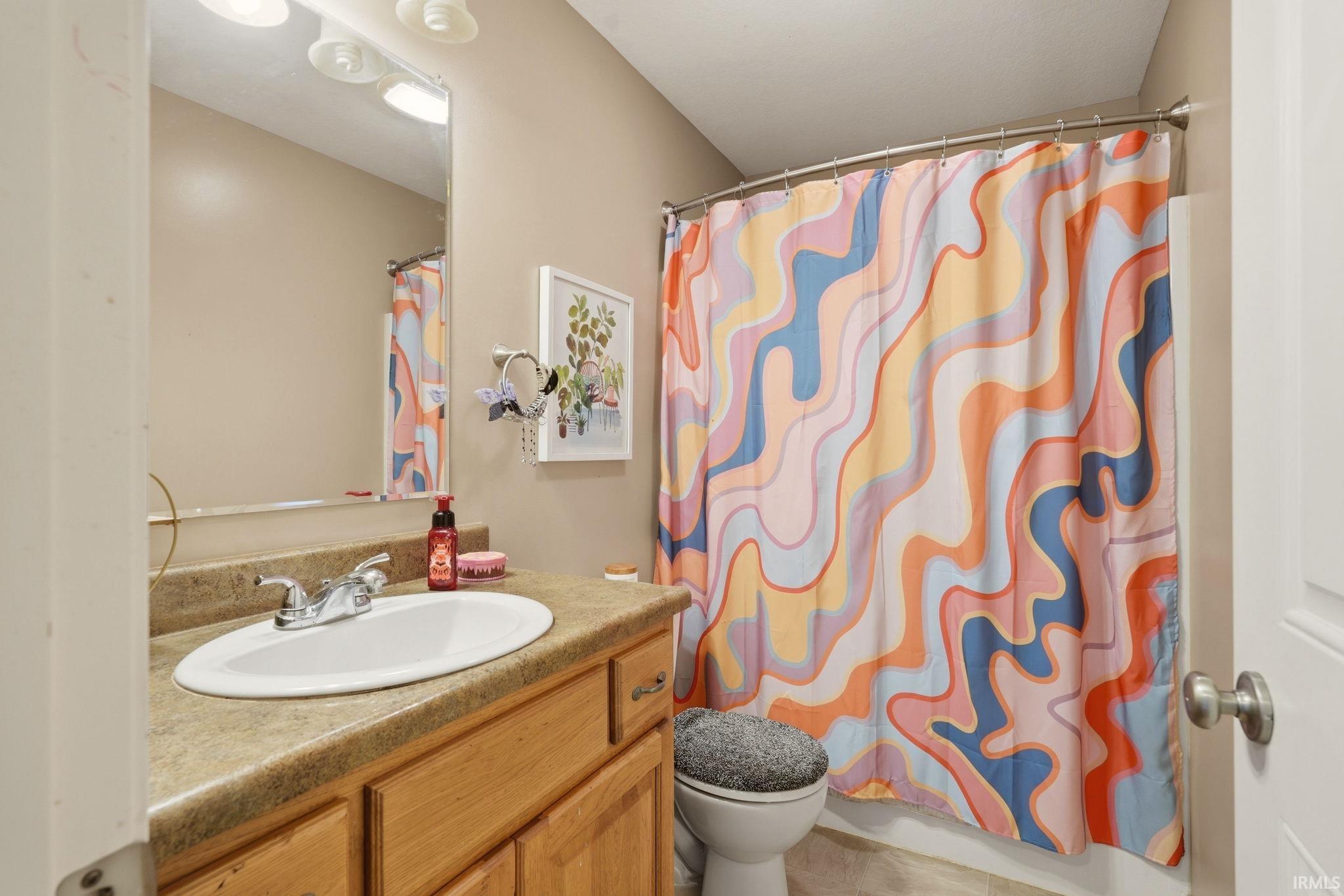 Bathroom vanity with a light wood-finish cabinet and a laminate countertop
