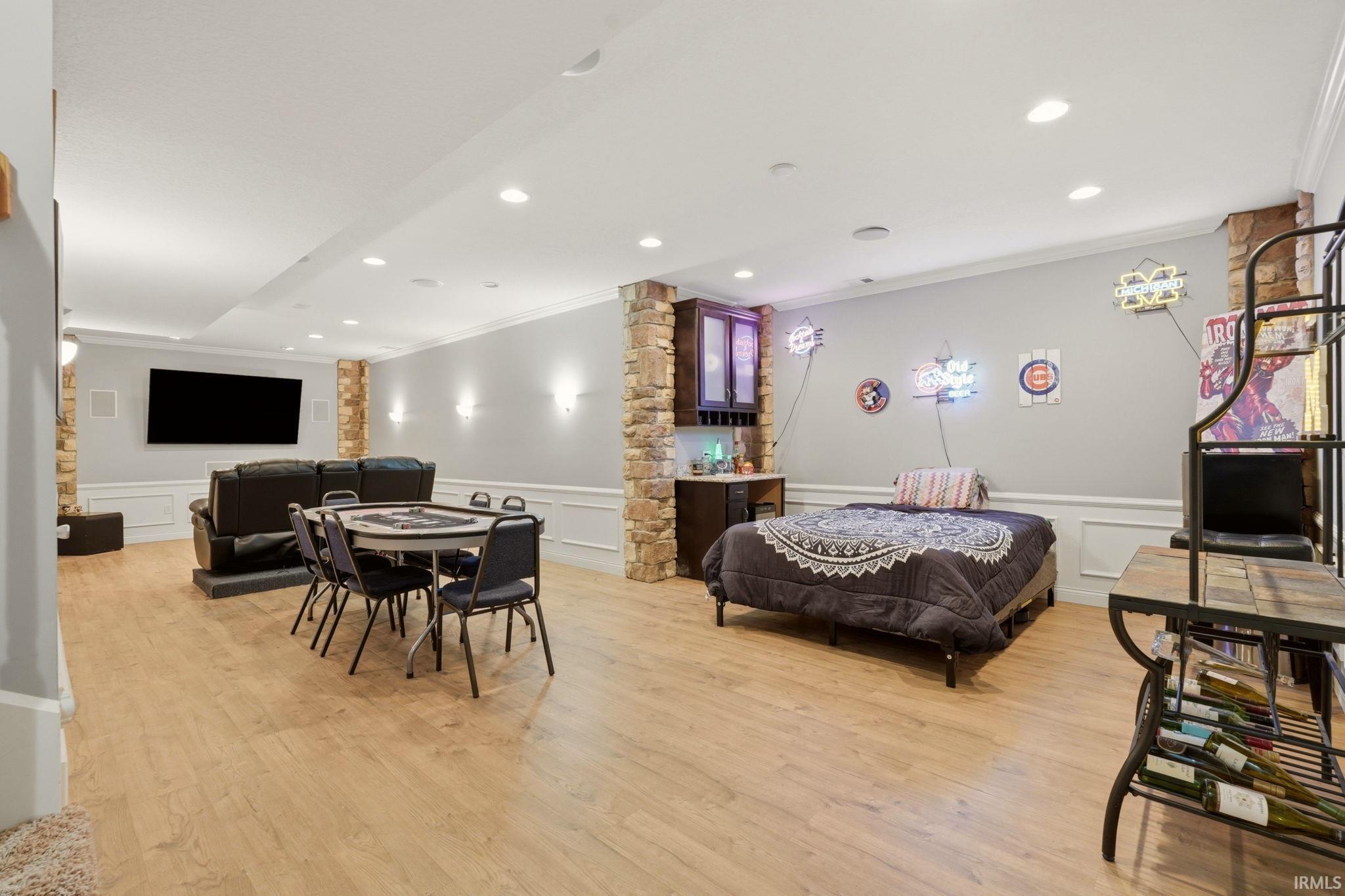 Spacious lower-level area featuring recessed lighting, light wood-finish flooring, and crown molding