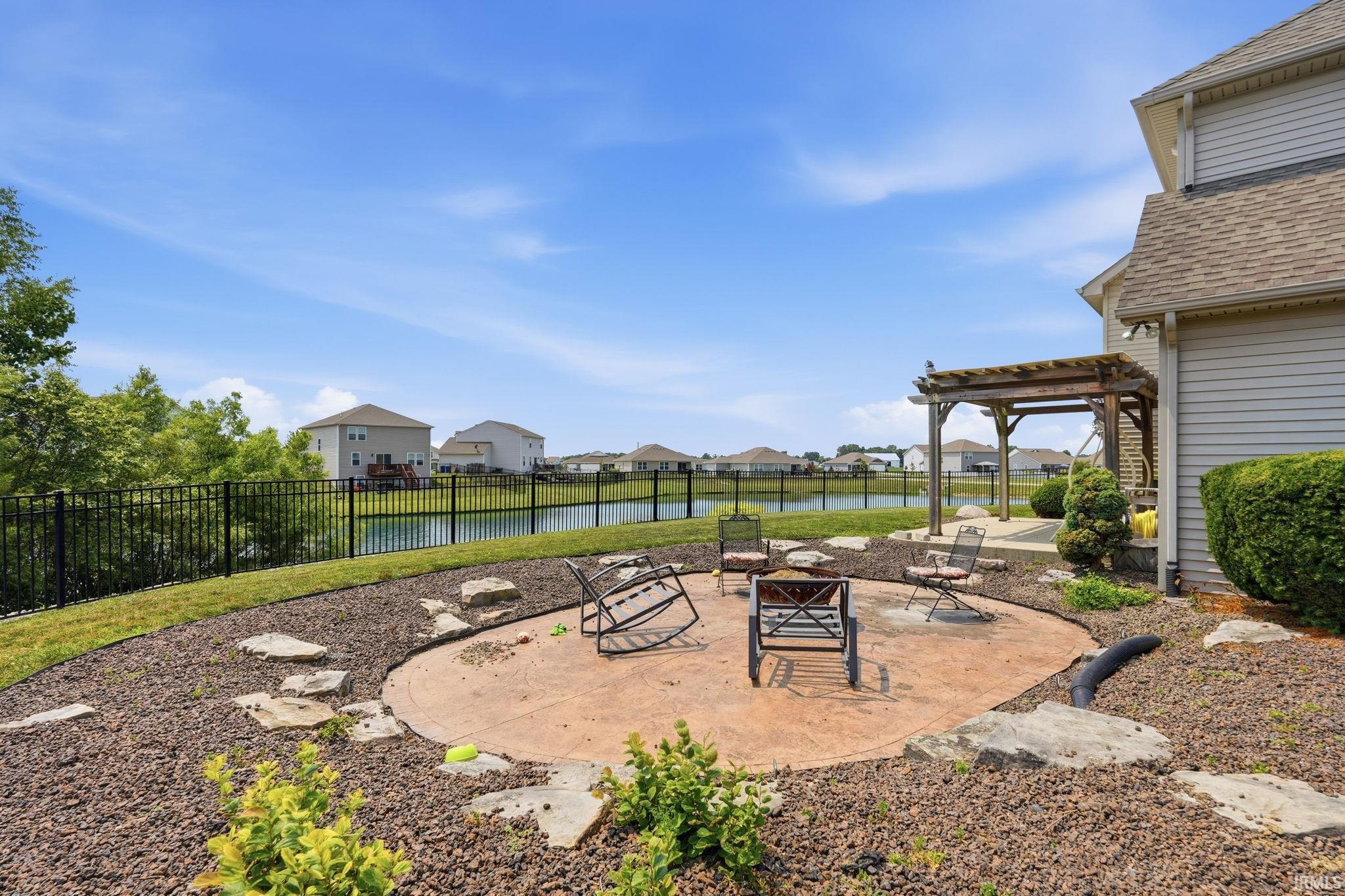 Outdoor patio featuring a concrete surface, surrounded by decorative gravel and stepping stones