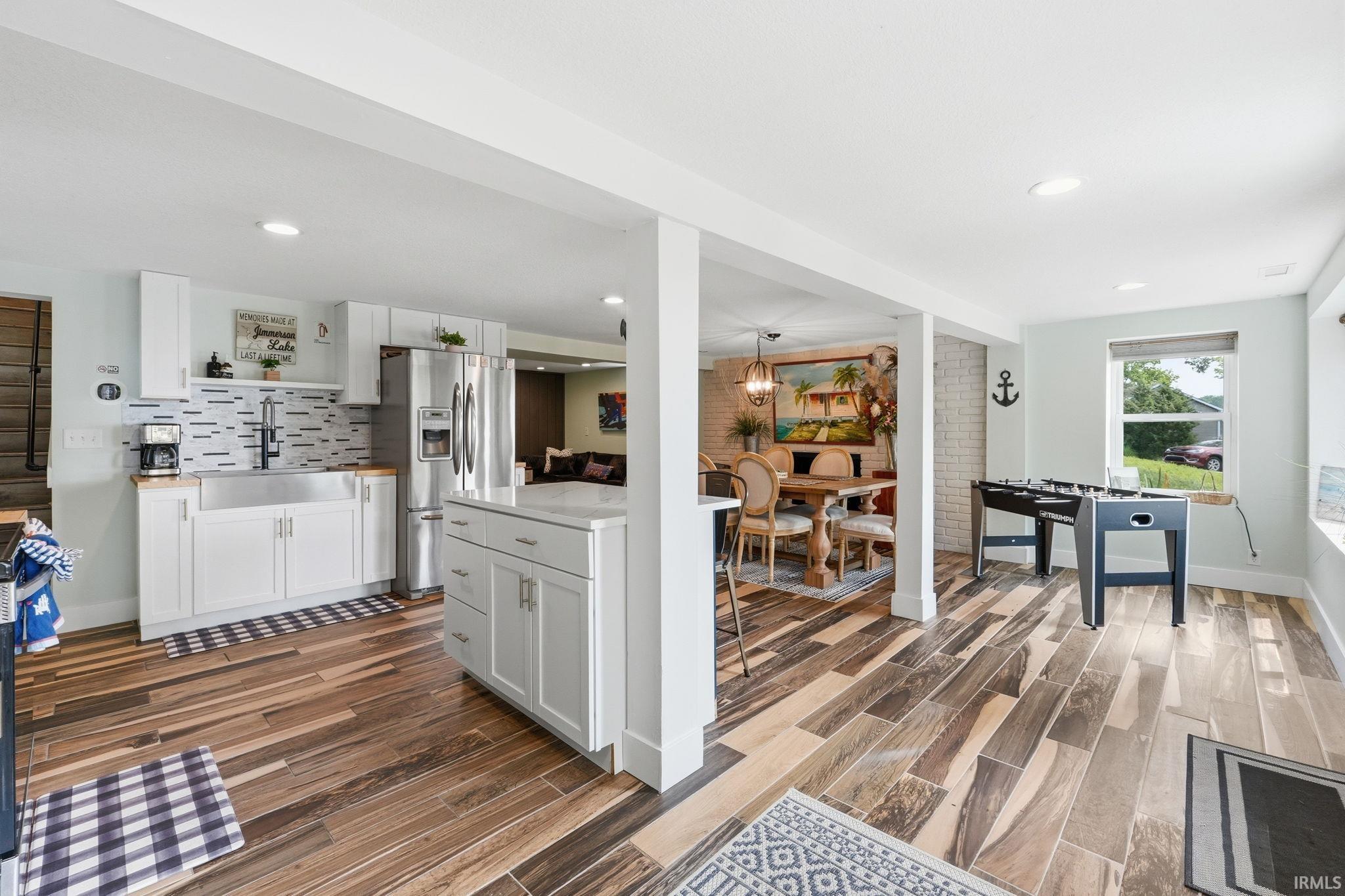 Modern kitchen with white cabinetry, stainless steel appliances, and a farmhouse-style sink