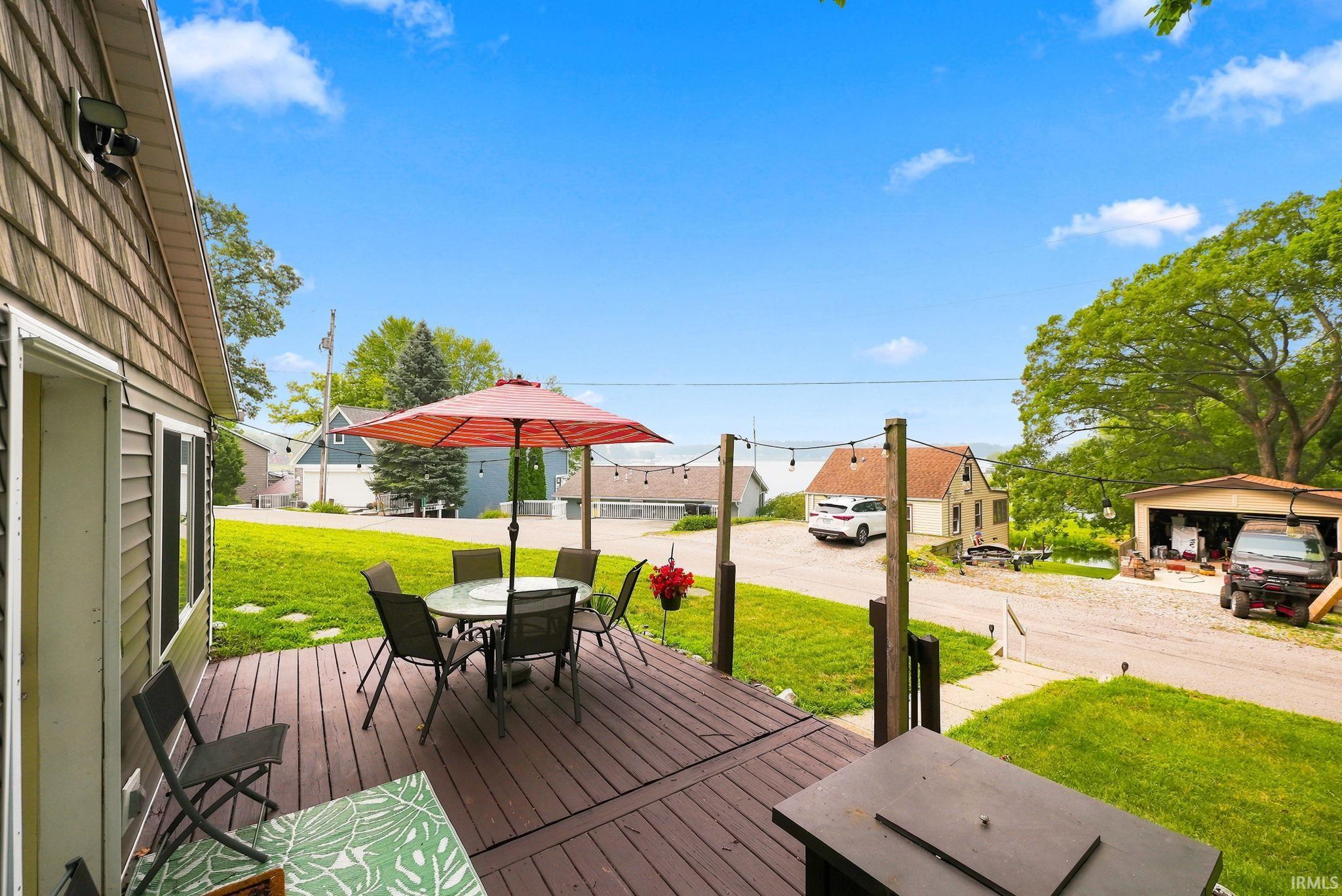 Wood-finish decking extends from the residence, providing an outdoor living area