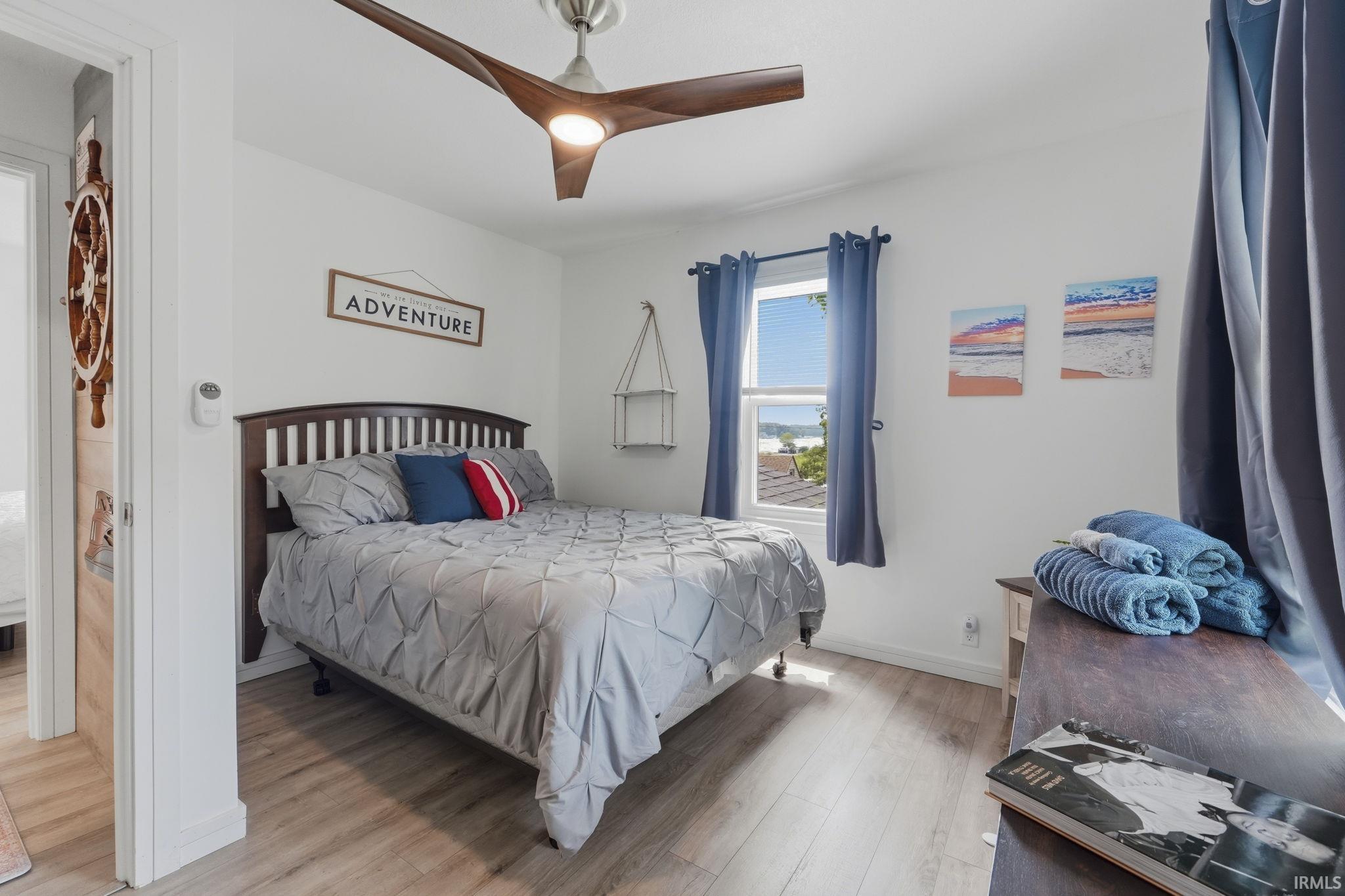 Bedroom featuring a dark wood bed frame, wood-finish flooring, and white walls