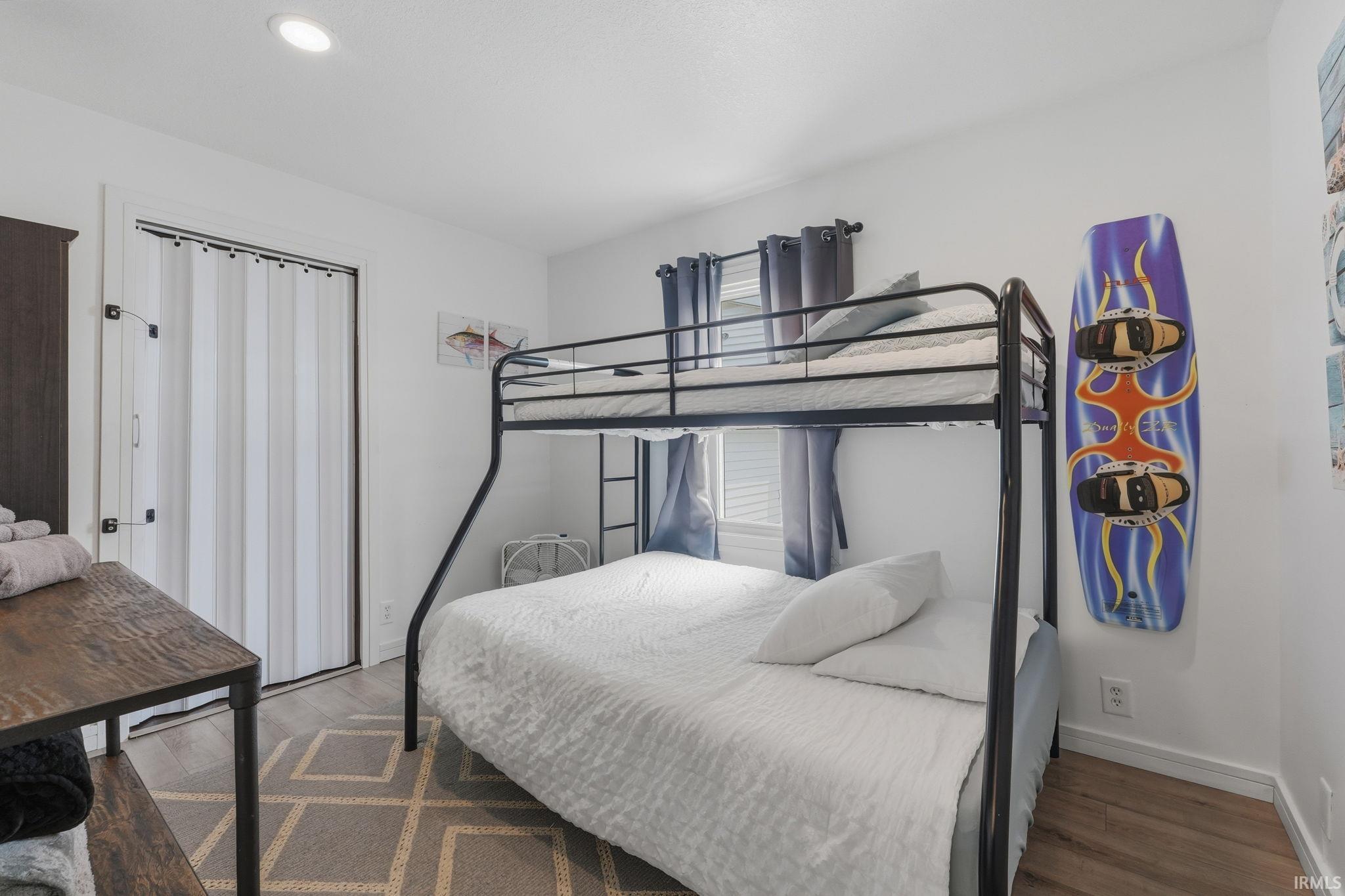 Room featuring a metal bunk bed, recessed lighting, and wood-finish flooring