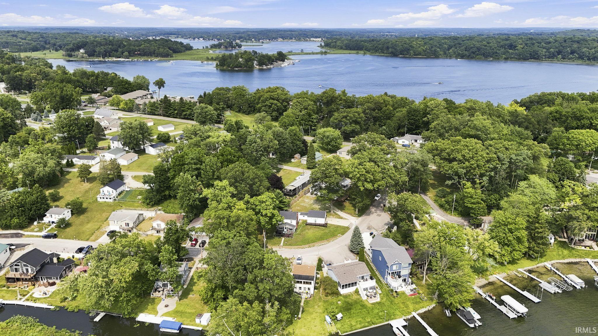 Expansive lakefront community featuring multiple docks, dense mature trees, and a variety of residential properties