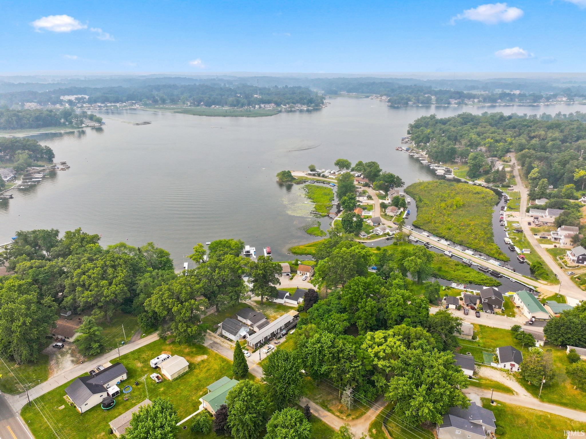 Aerial perspective showcasing a large body of water surrounded by verdant trees and residential properties