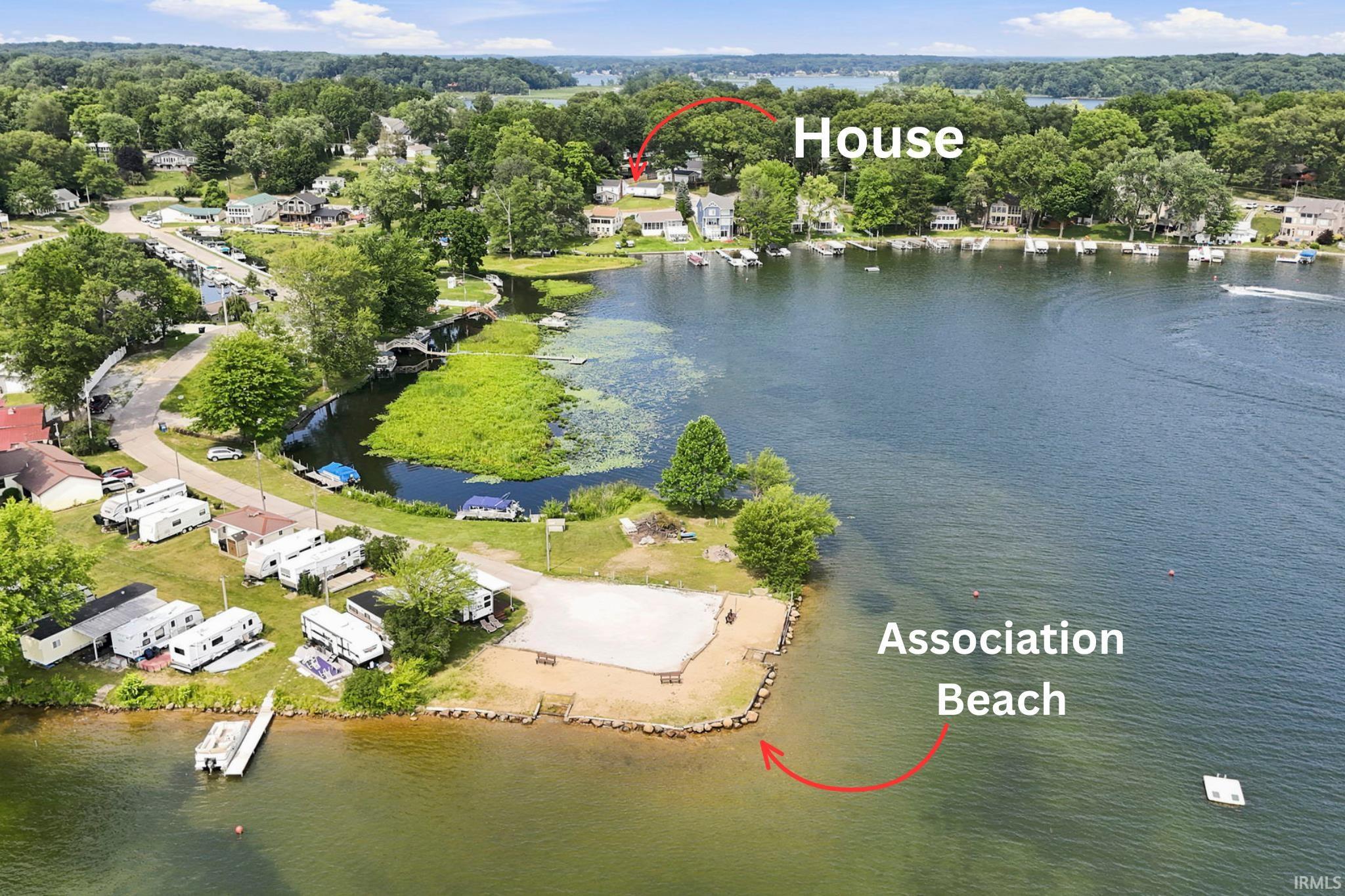 Expansive waterfront property featuring a private dock and a sandy association beach