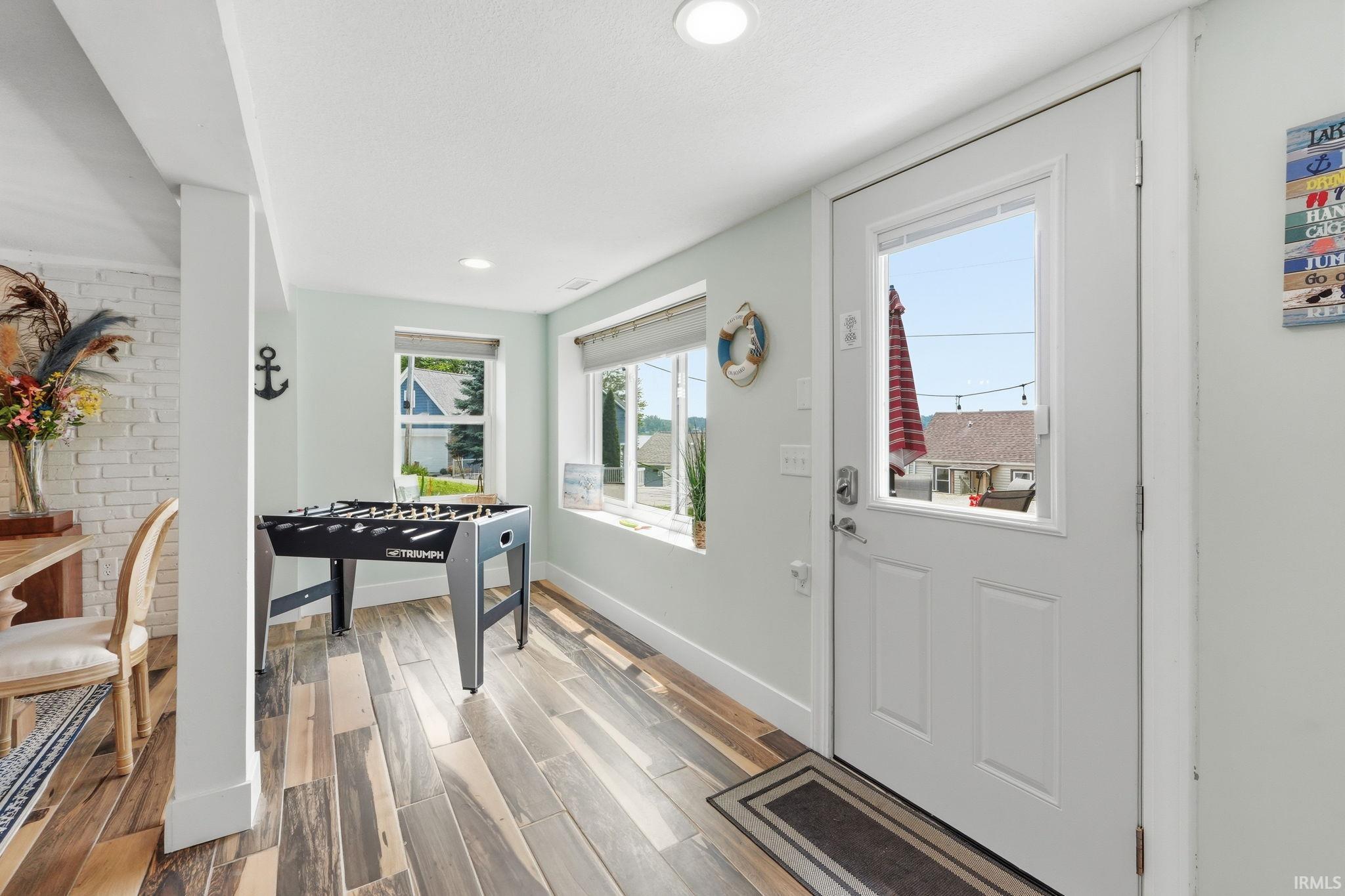 Bright interior space featuring multi-tone wood-finish flooring, recessed lighting, and large windows