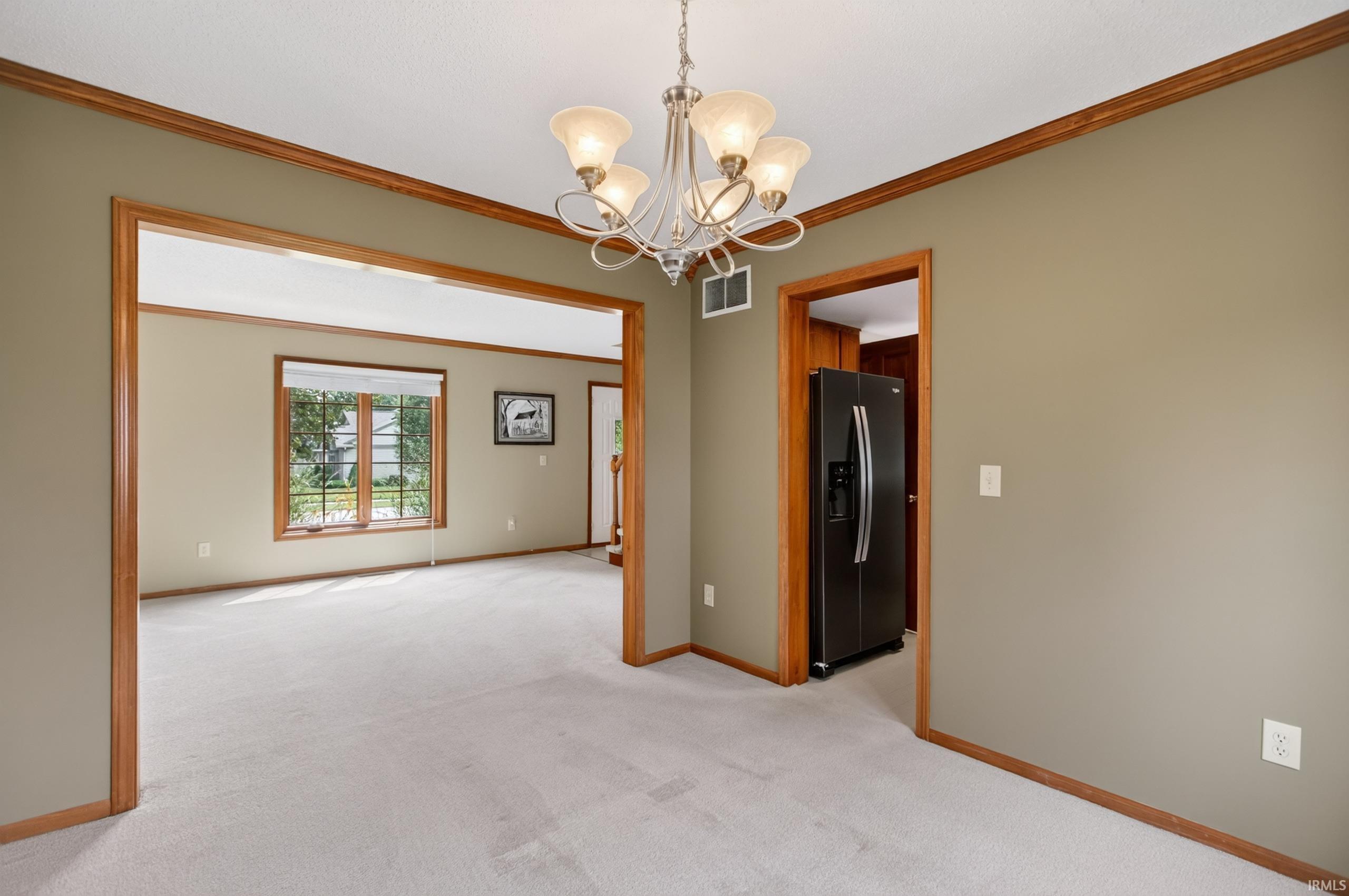 Carpeted room with a five-light chandelier