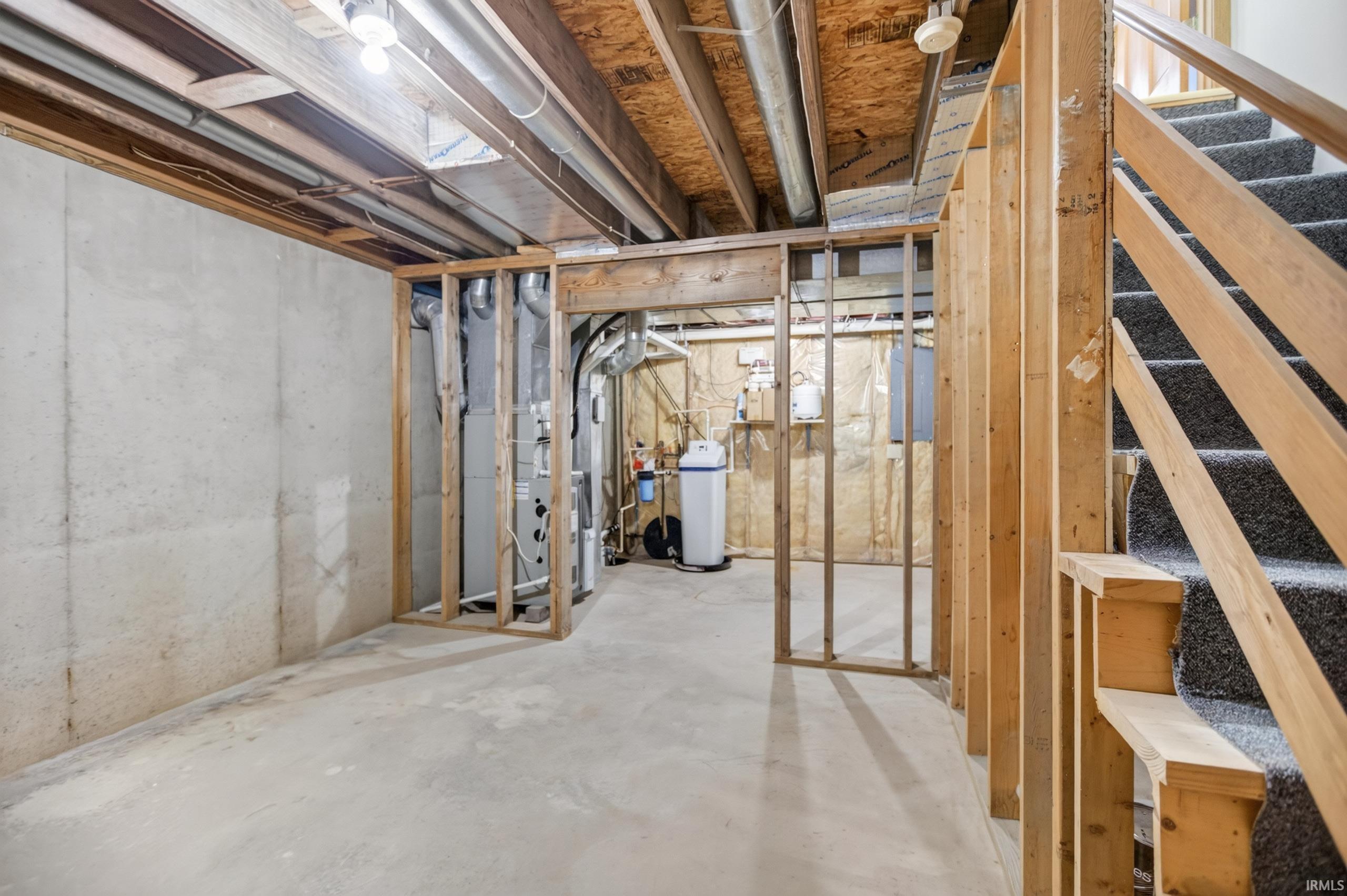 Unfinished basement with concrete flooring and exposed ceiling joists