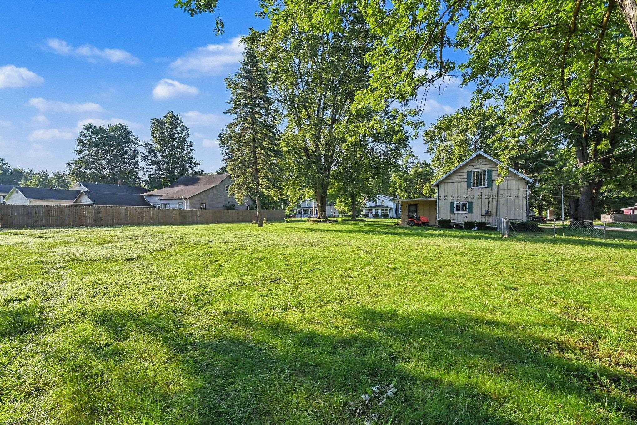 Expansive green lawn with a wood fence perimeter