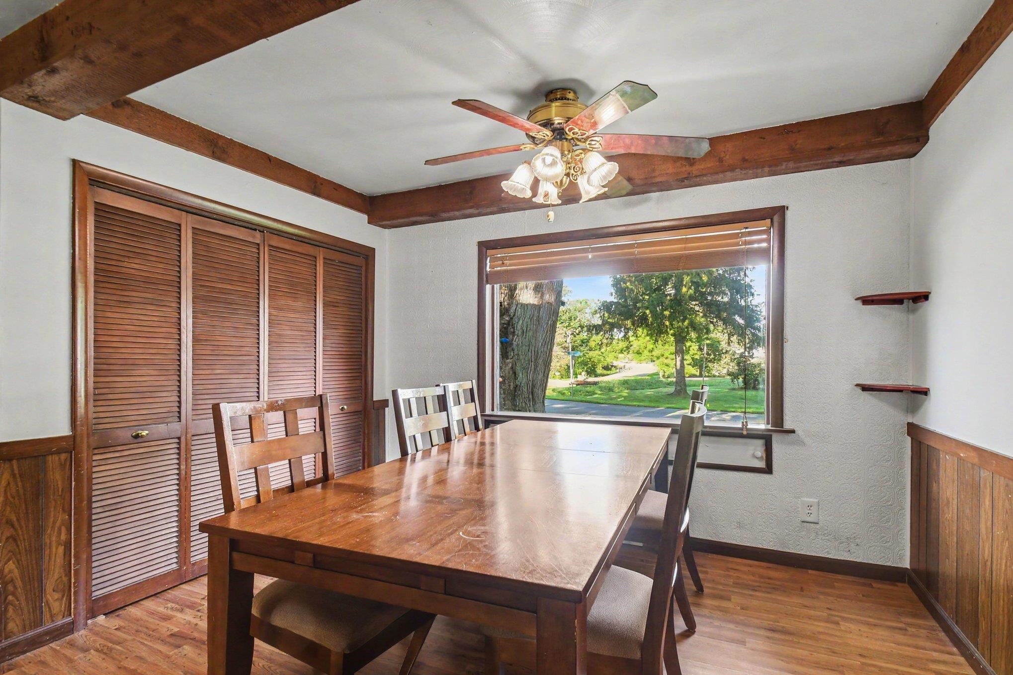 Wood-finish flooring with wood paneling and exposed ceiling beams