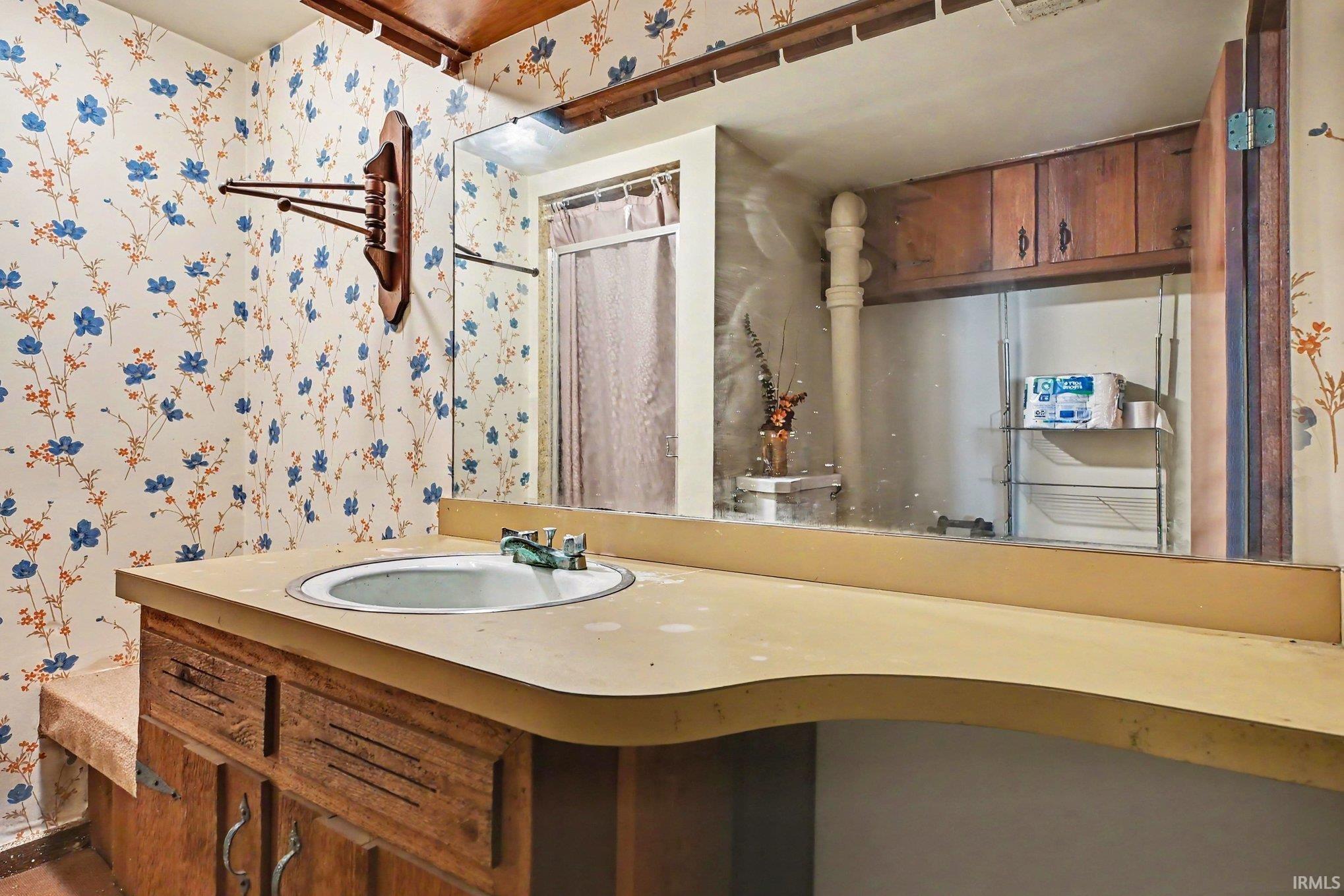 Vanity featuring a built-in sink, wood-finish cabinetry, and a countertop with integrated backsplash