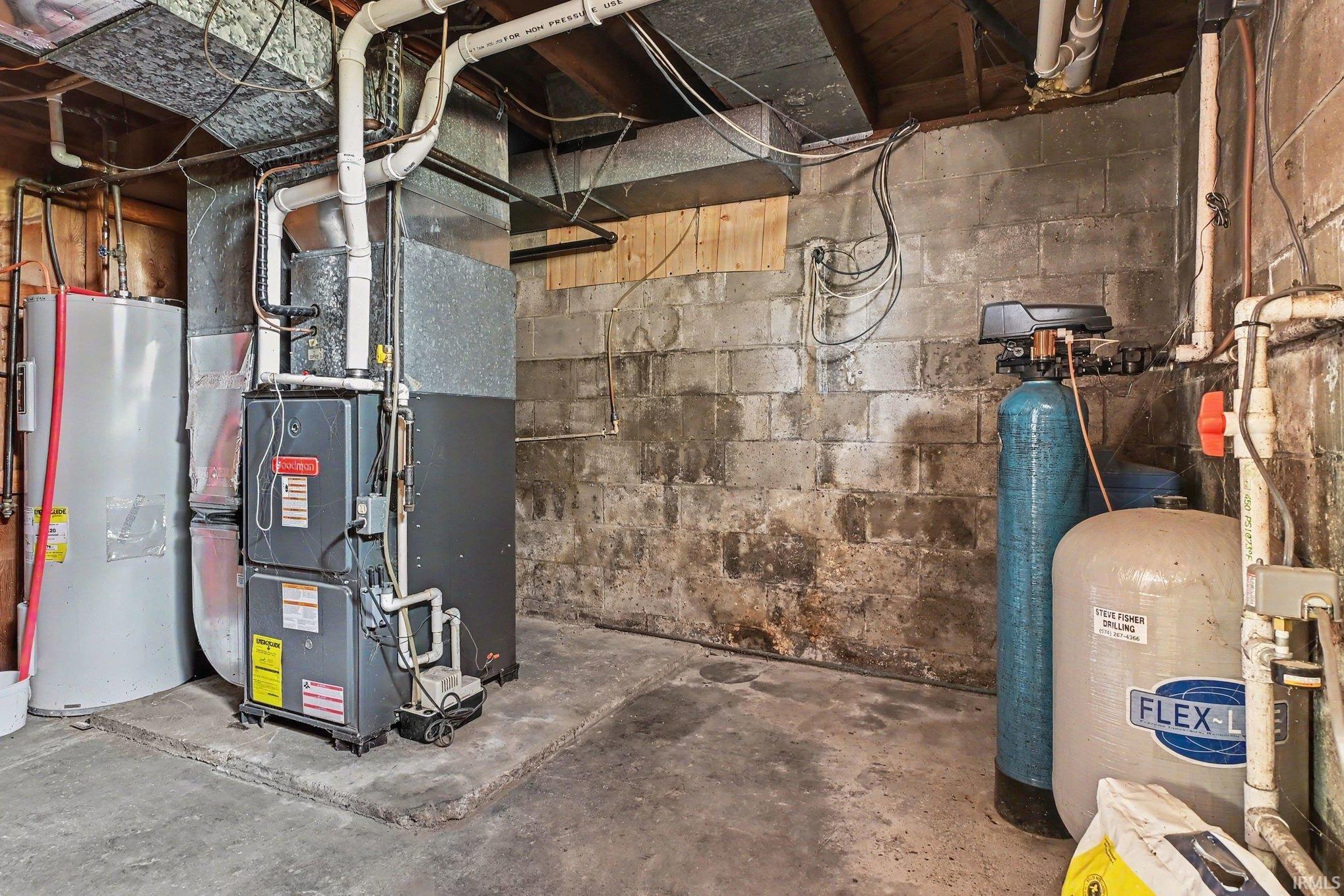 Utility area featuring a furnace, two water heaters, and water filtration system