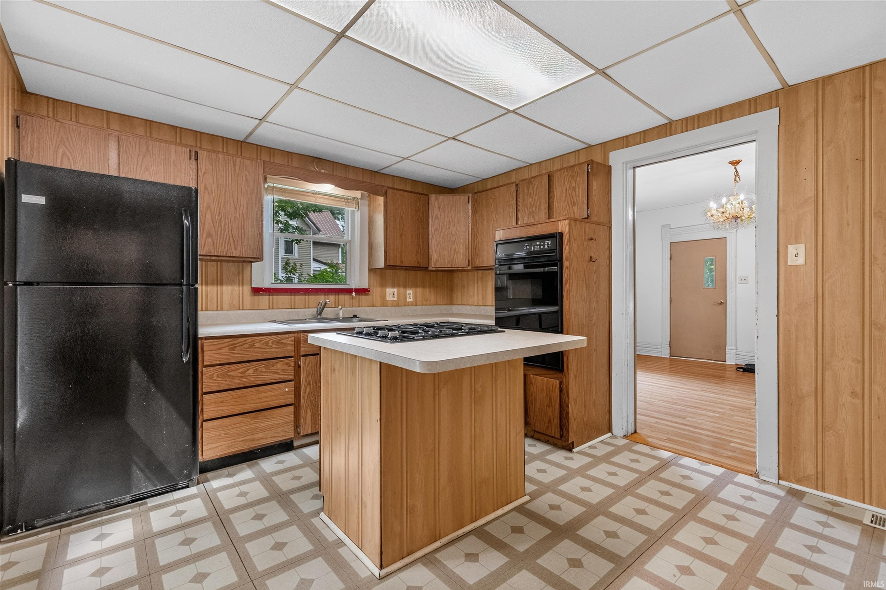 Kitchen featuring wood-finish cabinetry, a built-in oven, and a central island with a cooktop