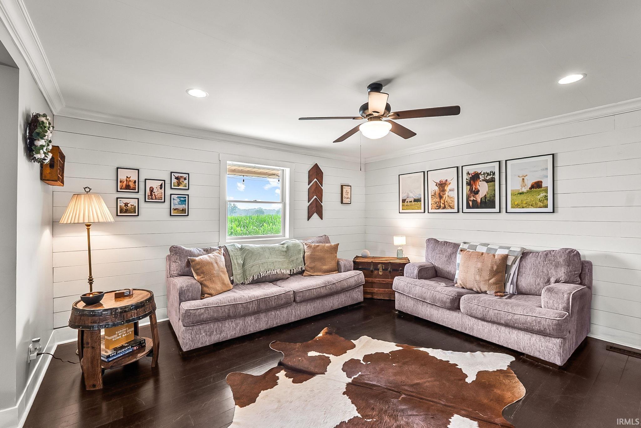 Living area featuring dark wood-finish flooring, white shiplap walls, recessed lighting, and a ceiling fan with light fixture