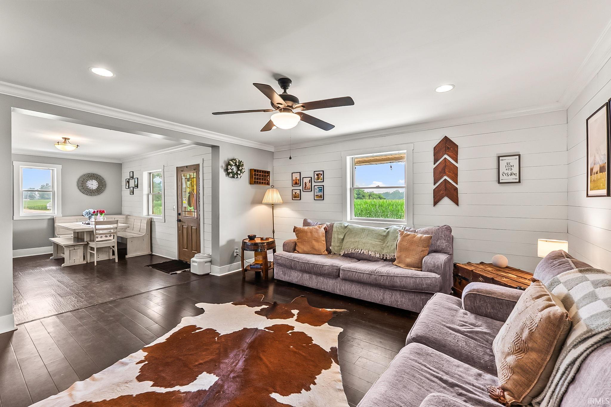 Open concept living and dining area featuring wood-finish flooring